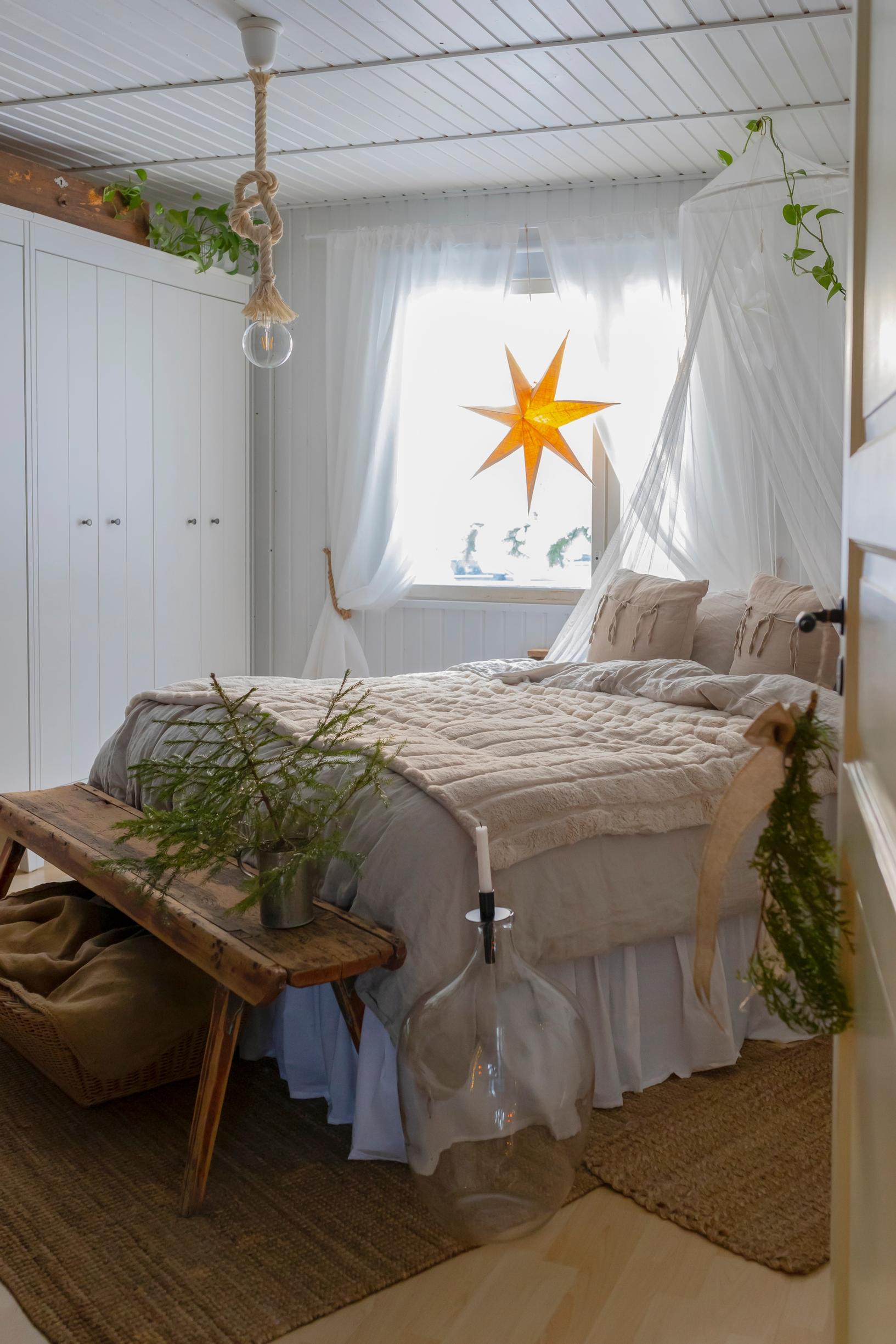 A bedroom with a bench at the foot of the bed