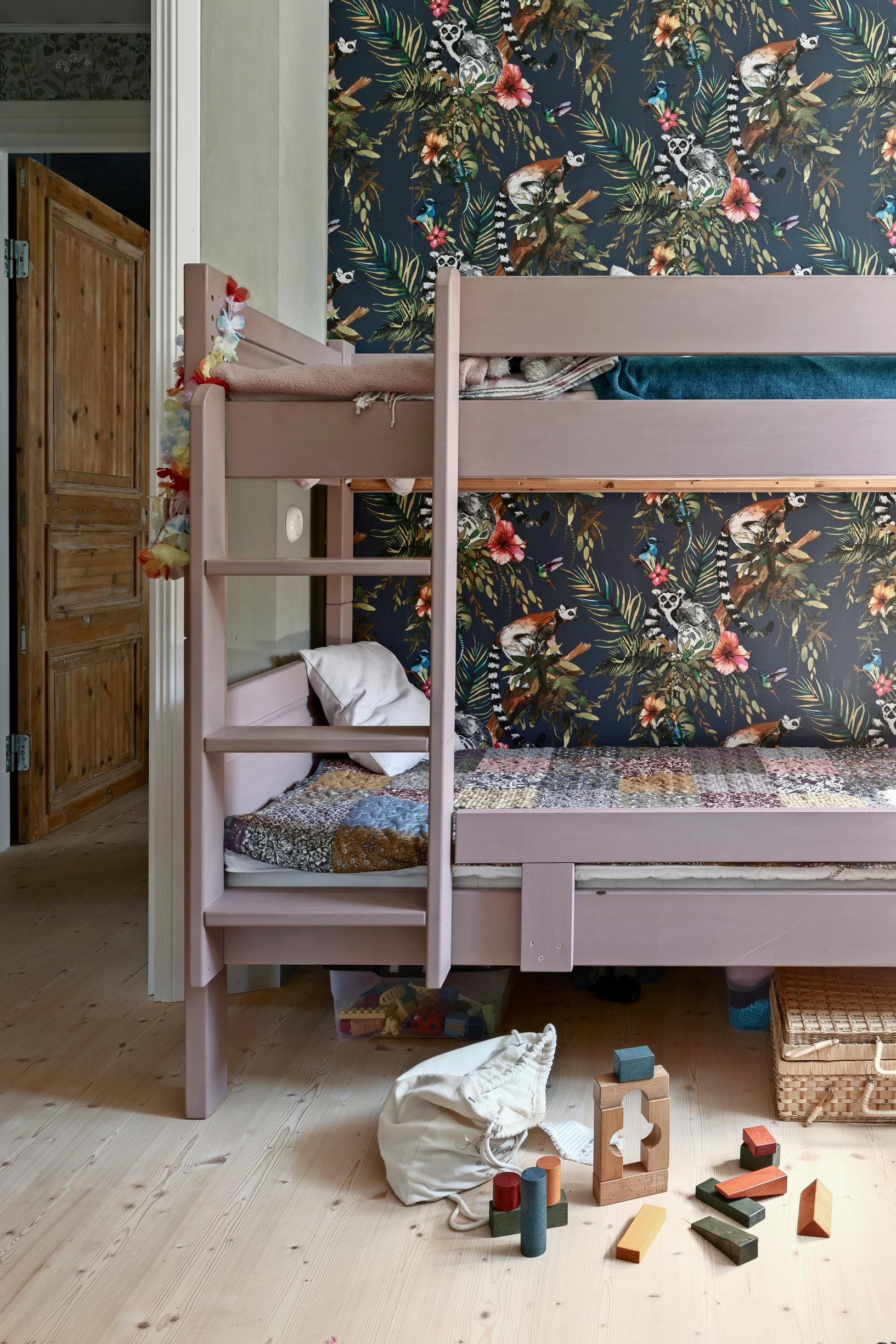 A bunk bed and floral wallpaper in the children’s room