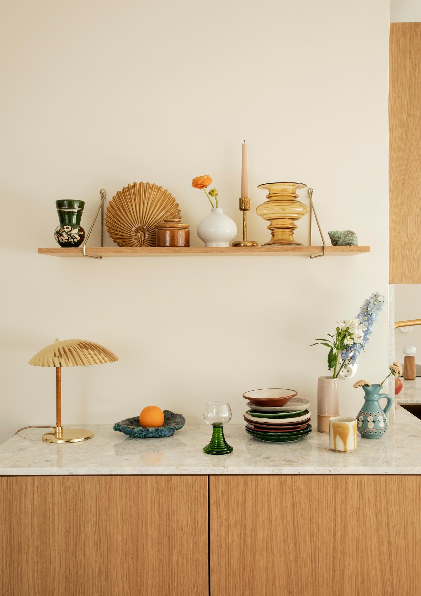Vintage dishes on a marble countertop in the built-in kitchen cabinets.