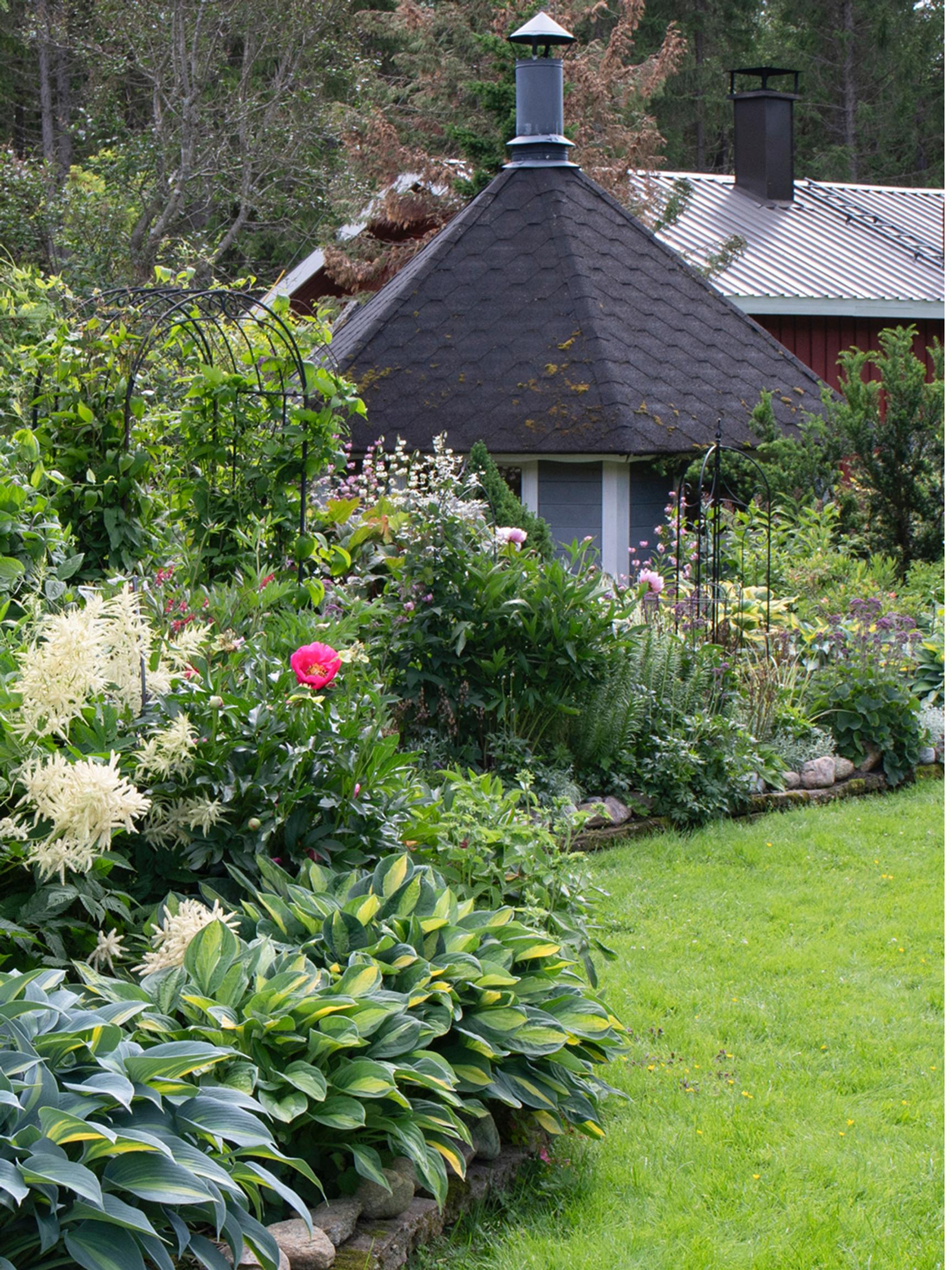 1,500 different species thrive in this plant collector’s garden—stone borders keep the beds in shape and make maintenance easier