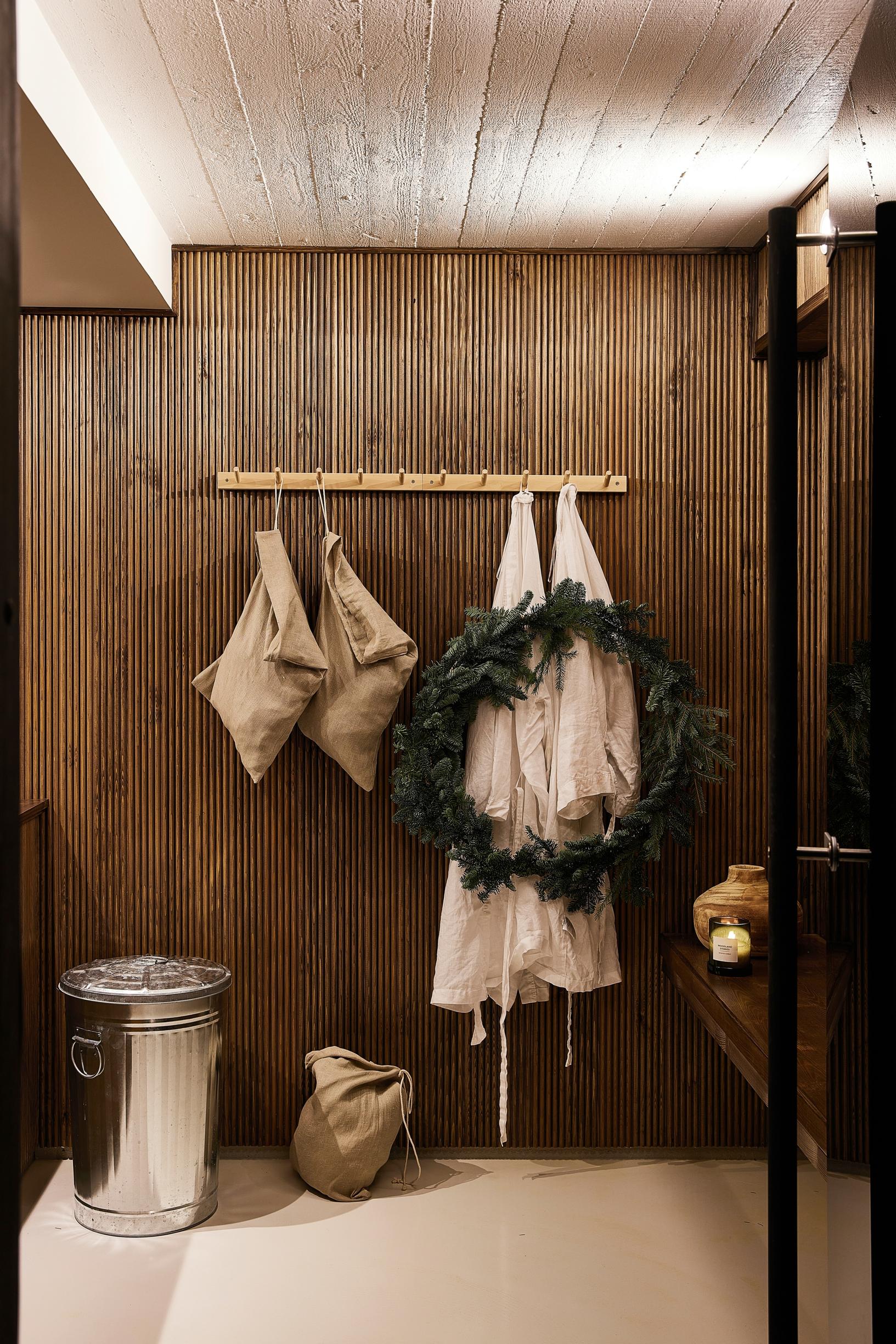 In the sauna dressing room, a dark slatted wall.
