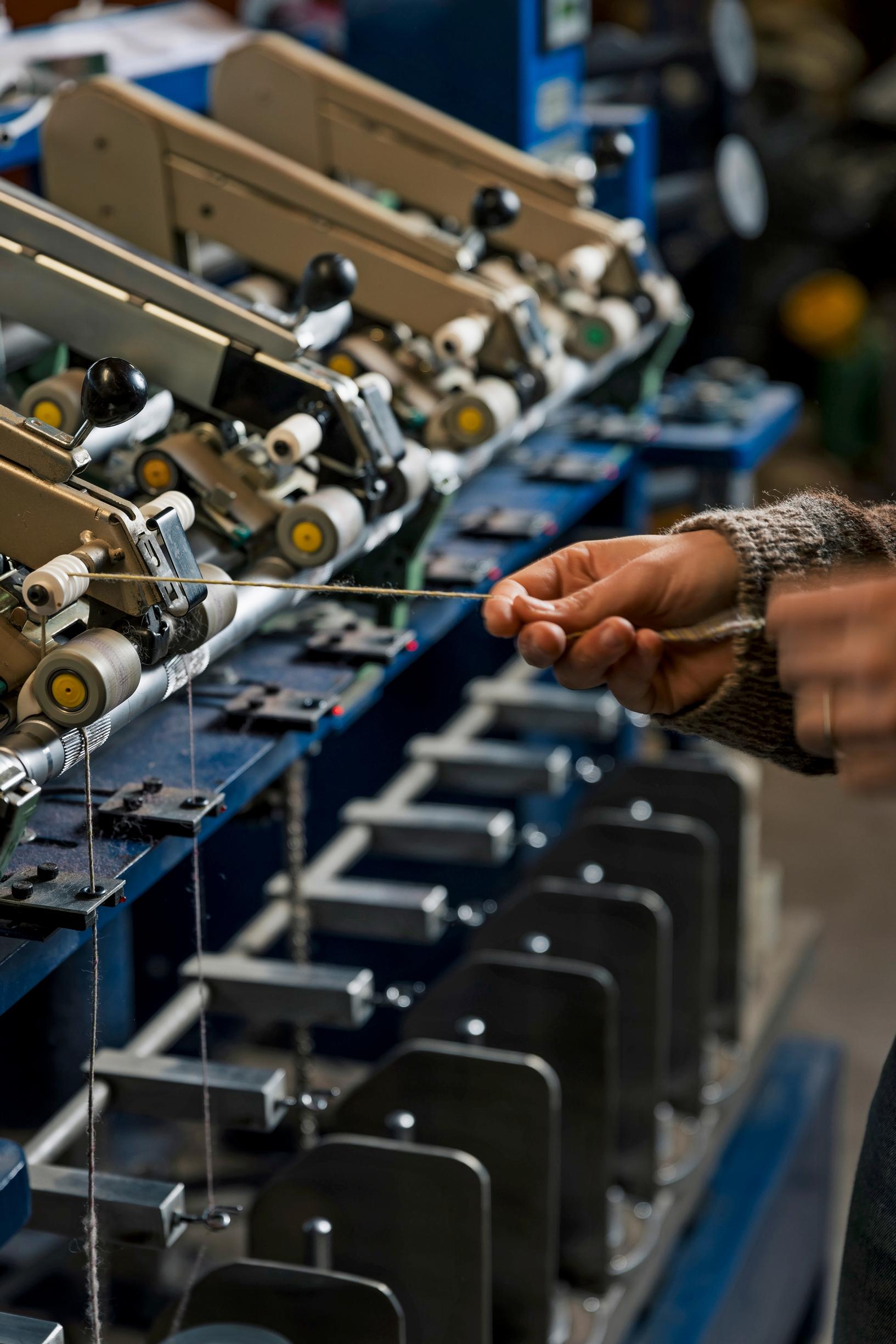 Yarn coming from the spinning machine into someone’s hands