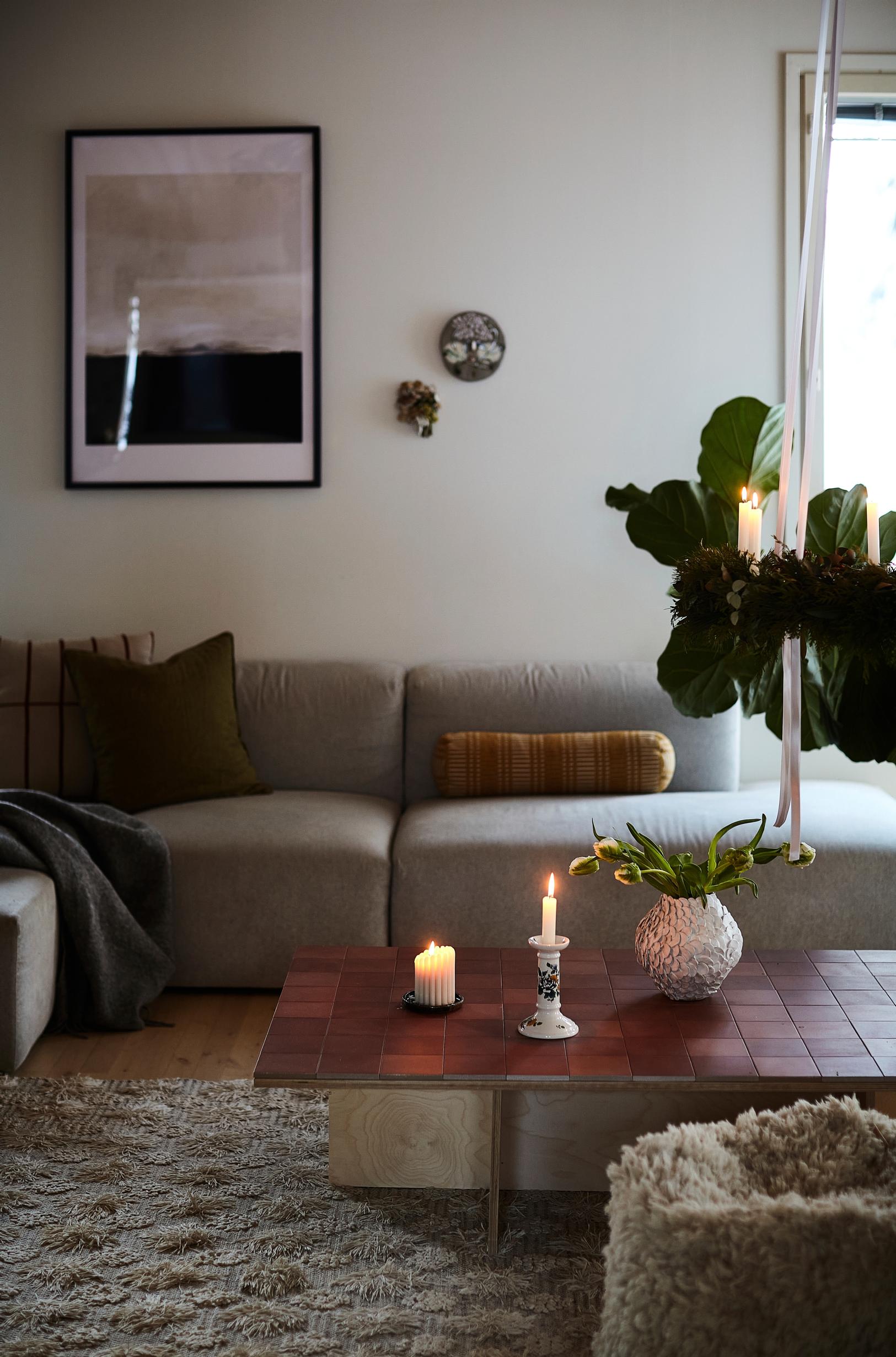 A sofa, coffee table, houseplant, and decorative objects on the coffee table