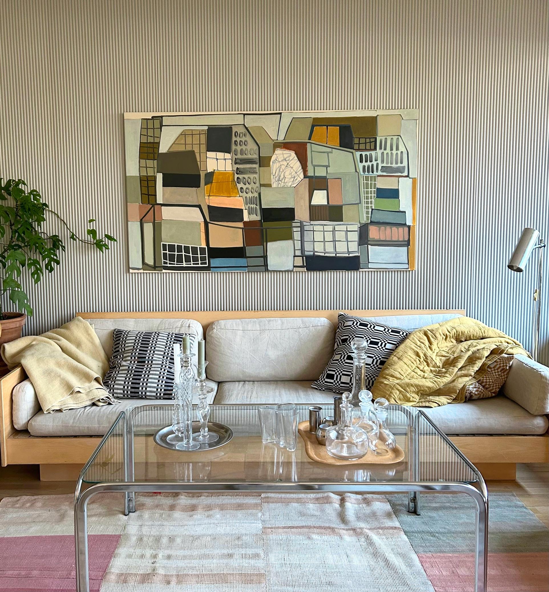 Modern, large painting above a wooden sofa