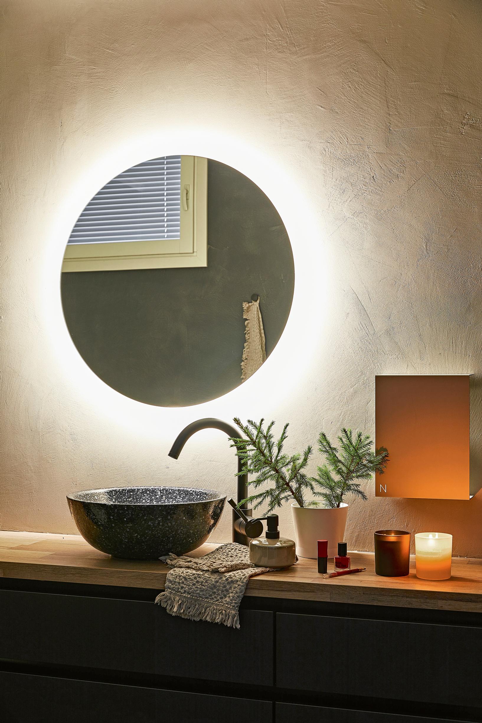 in the bathroom, a vessel sink, faucet, tealight candle, lighted mirror, and conifer decoration