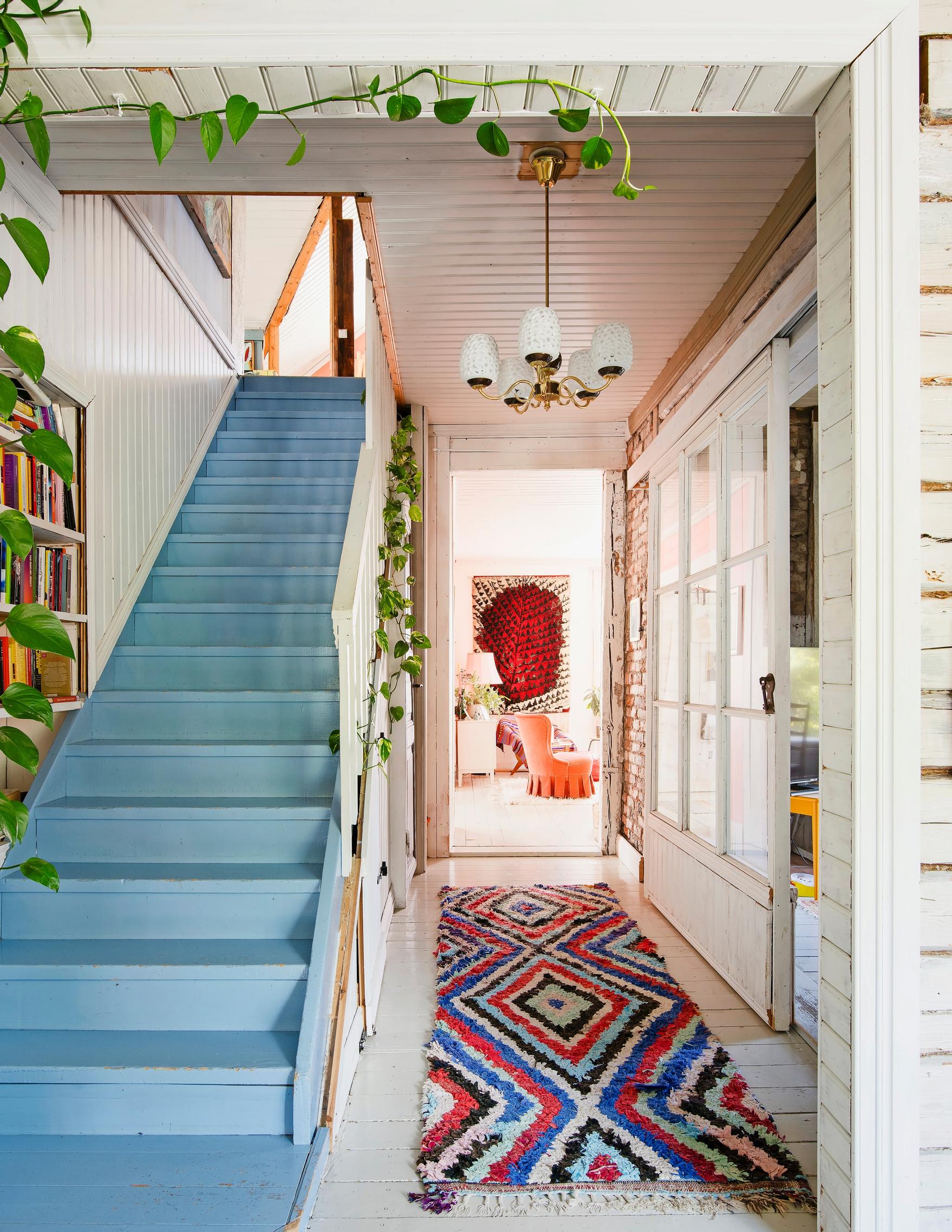 Photo of the entrance hall with a blue wooden staircase.