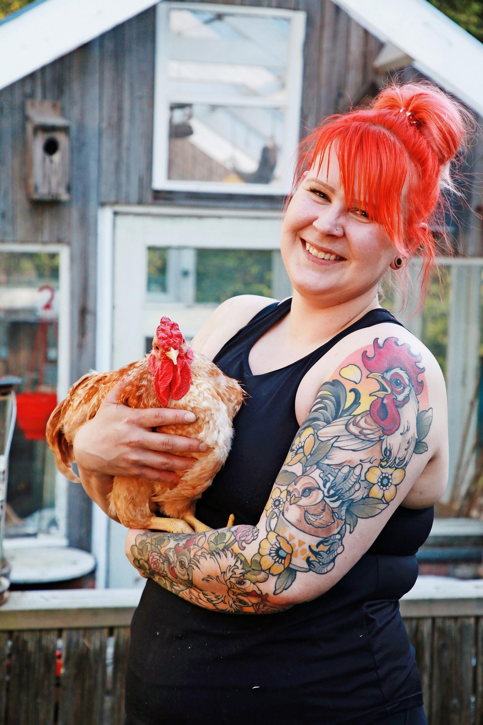 Anna-Kaisa holds a hen in her arms.