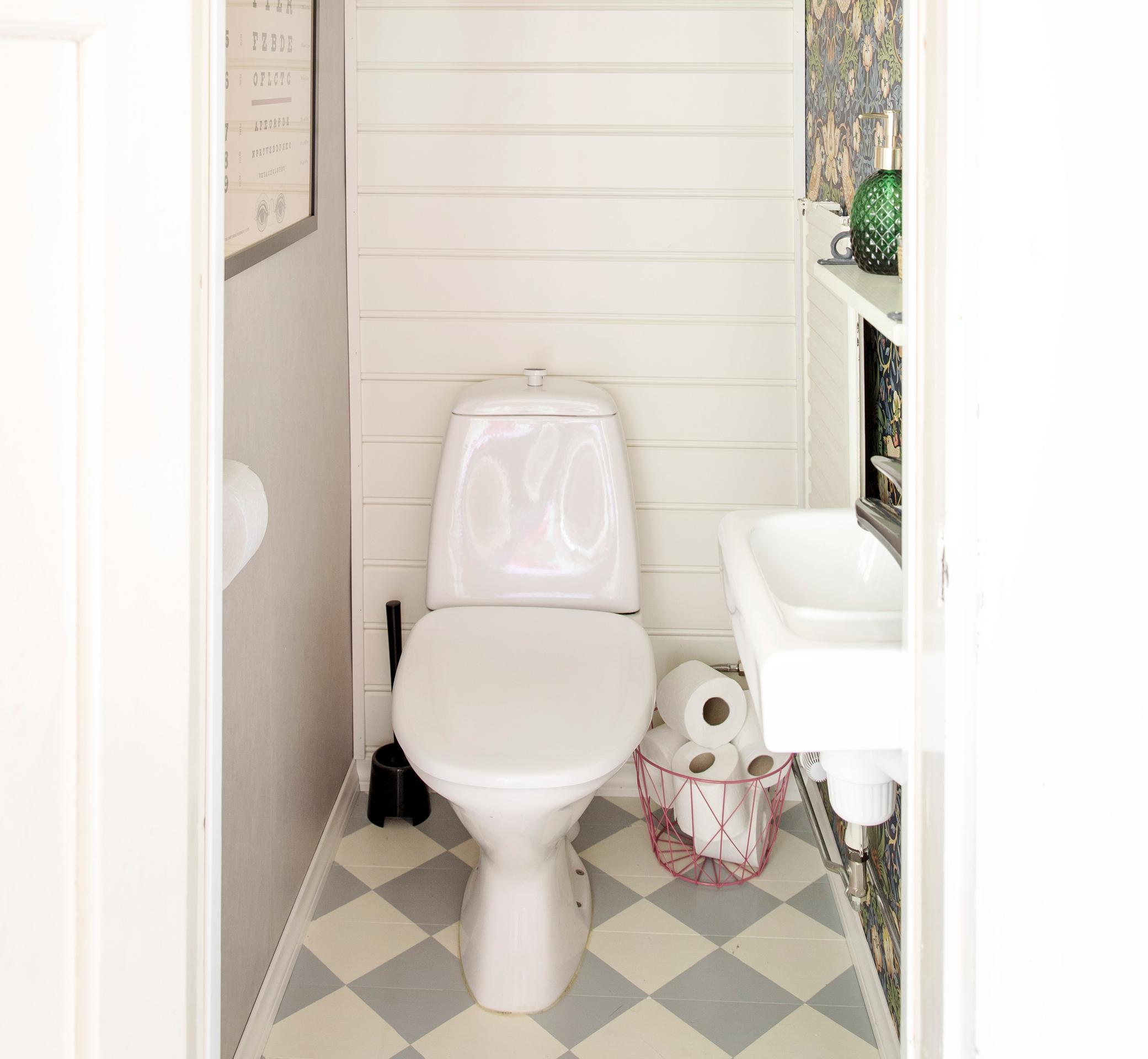 a traditional toilet in a white and gray-toned bathroom