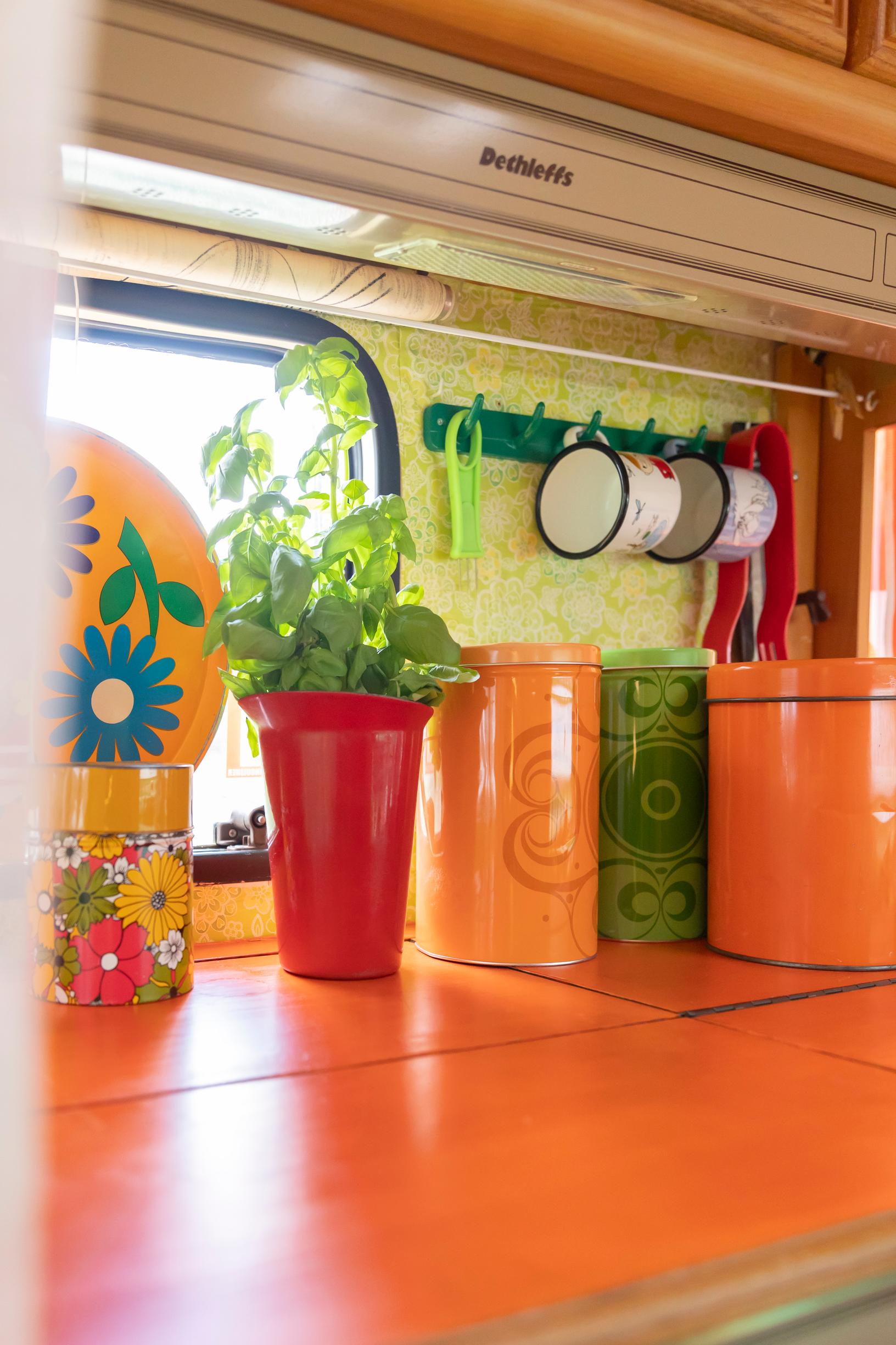 colorful containers on the kitchen counter inside the travel trailer