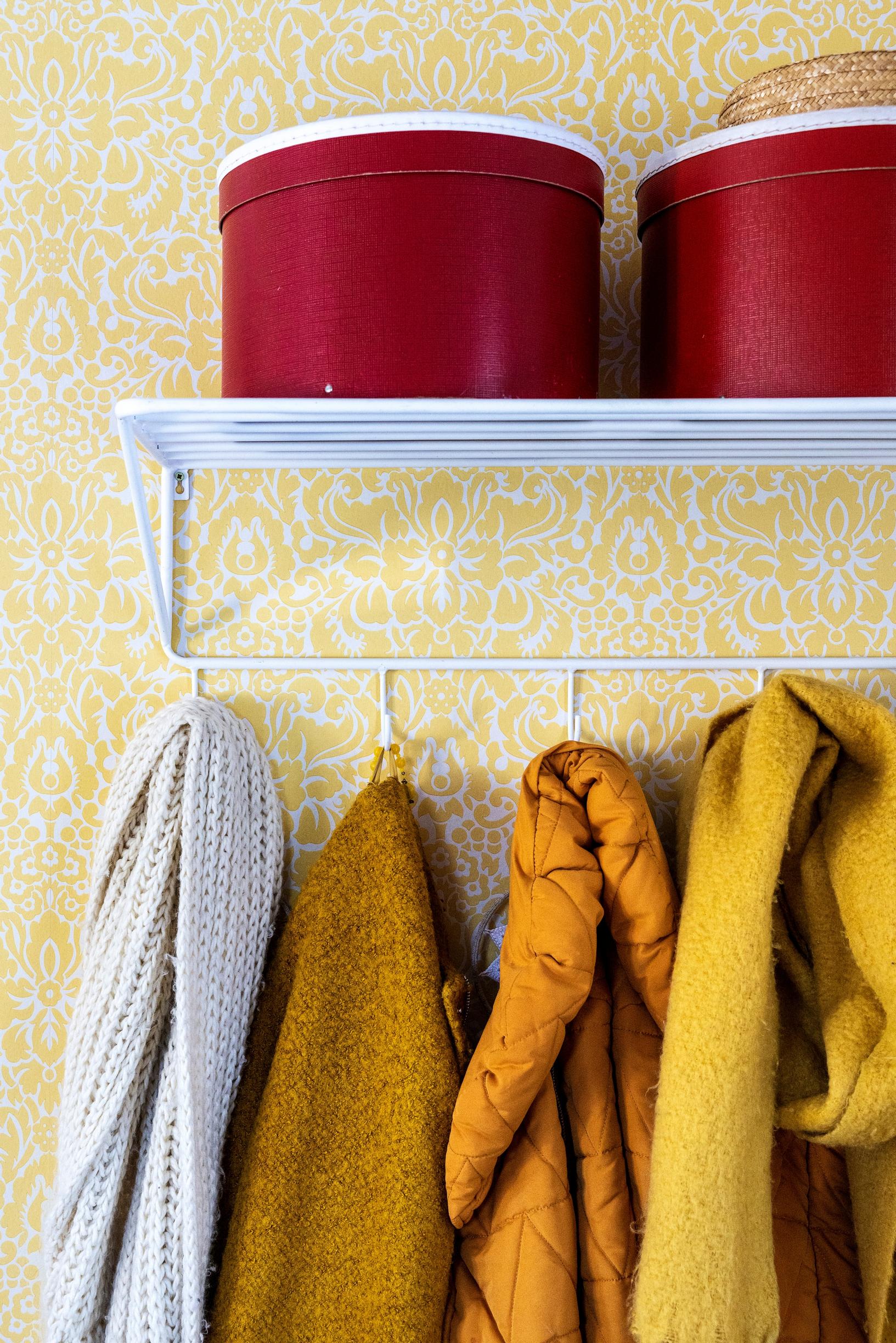 Yellow wallpaper and a retro coat rack.