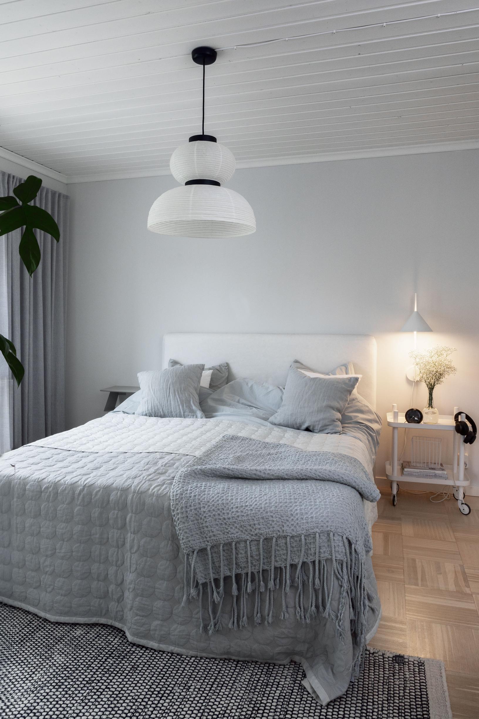 Parents’ bedroom with a double bed and light gray walls.