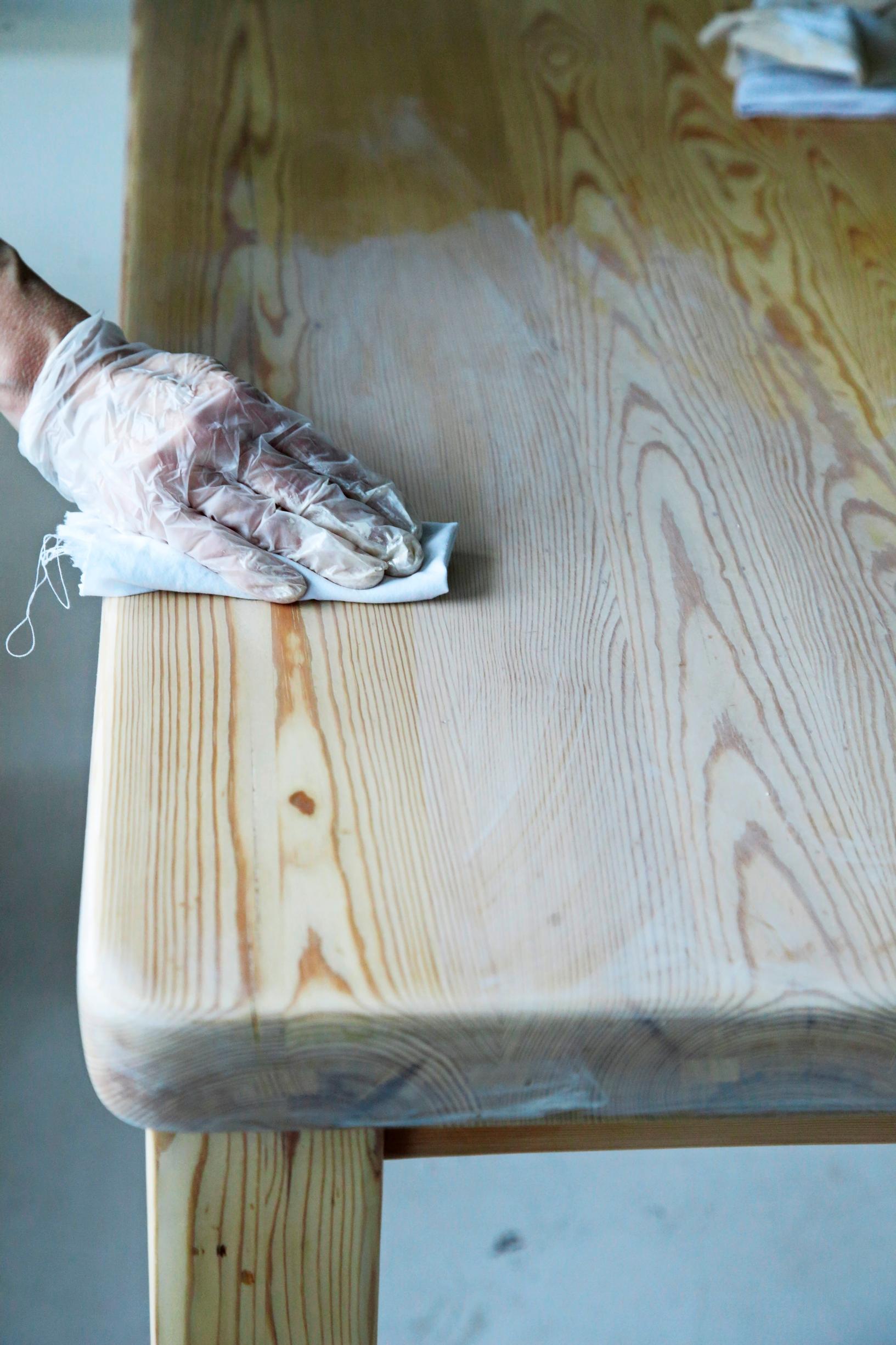 Wiping off excess wax from the table surface