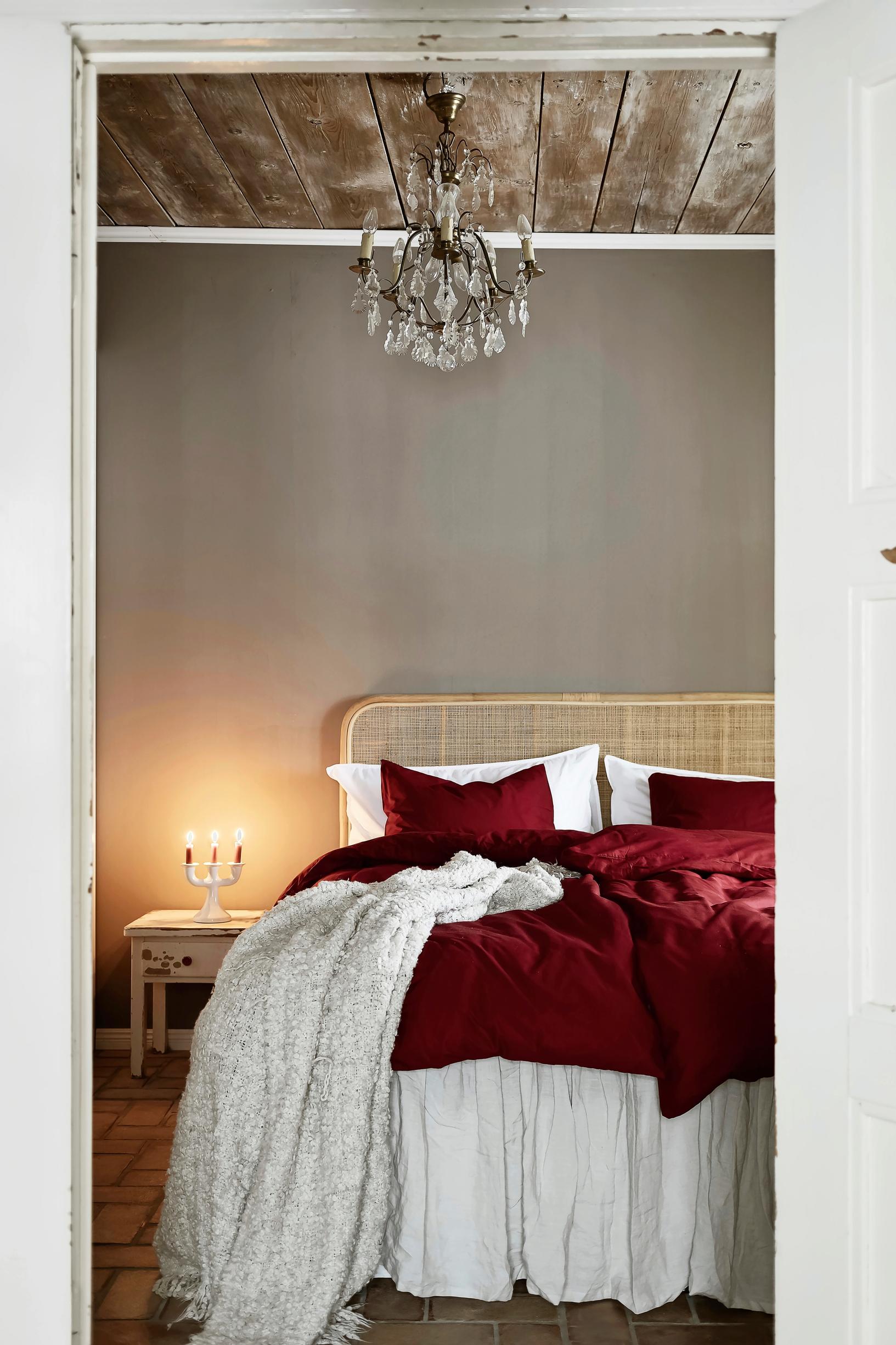 Red bedding on the bedroom bed.