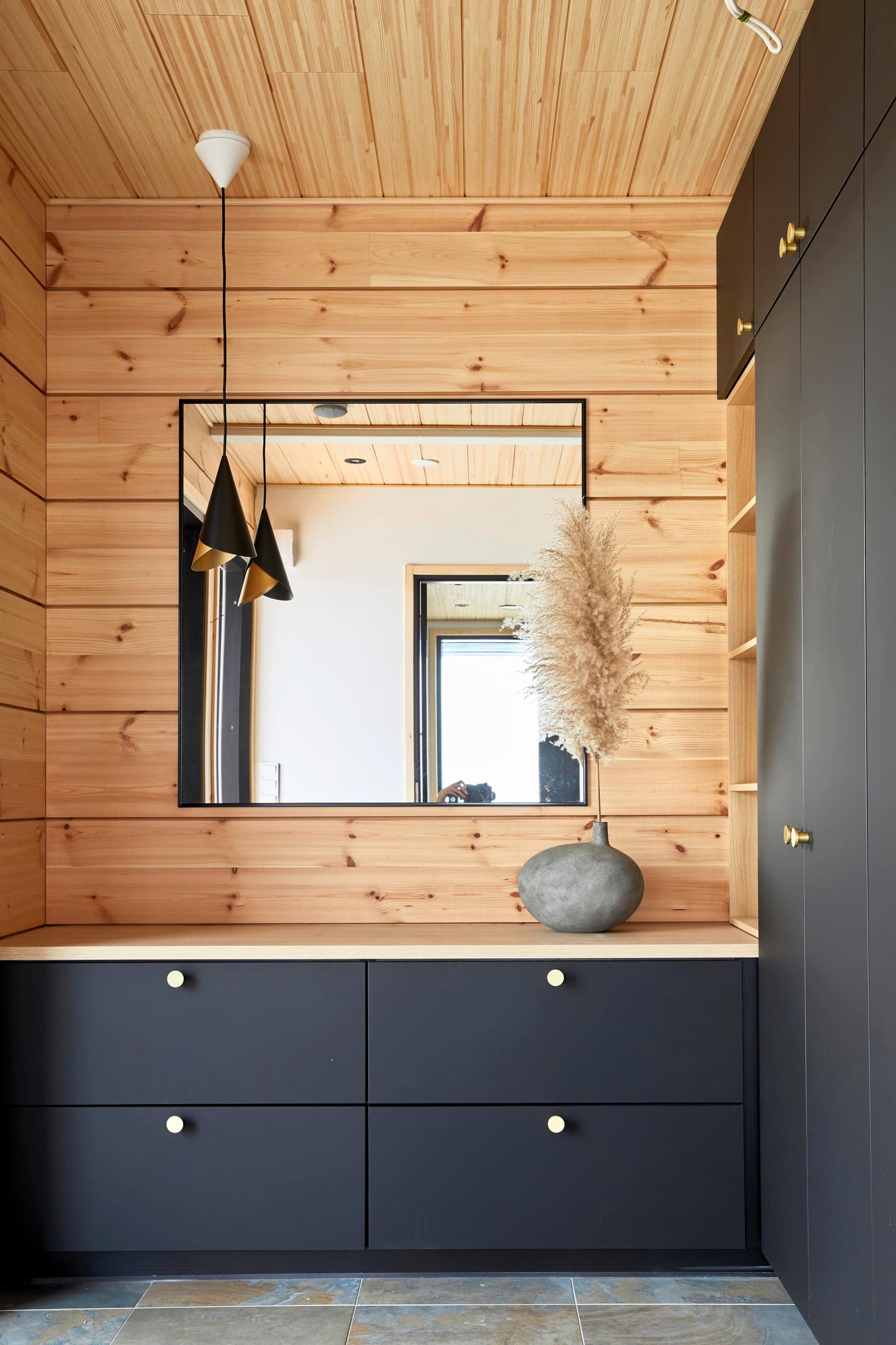A new log wall and dark gray storage furniture