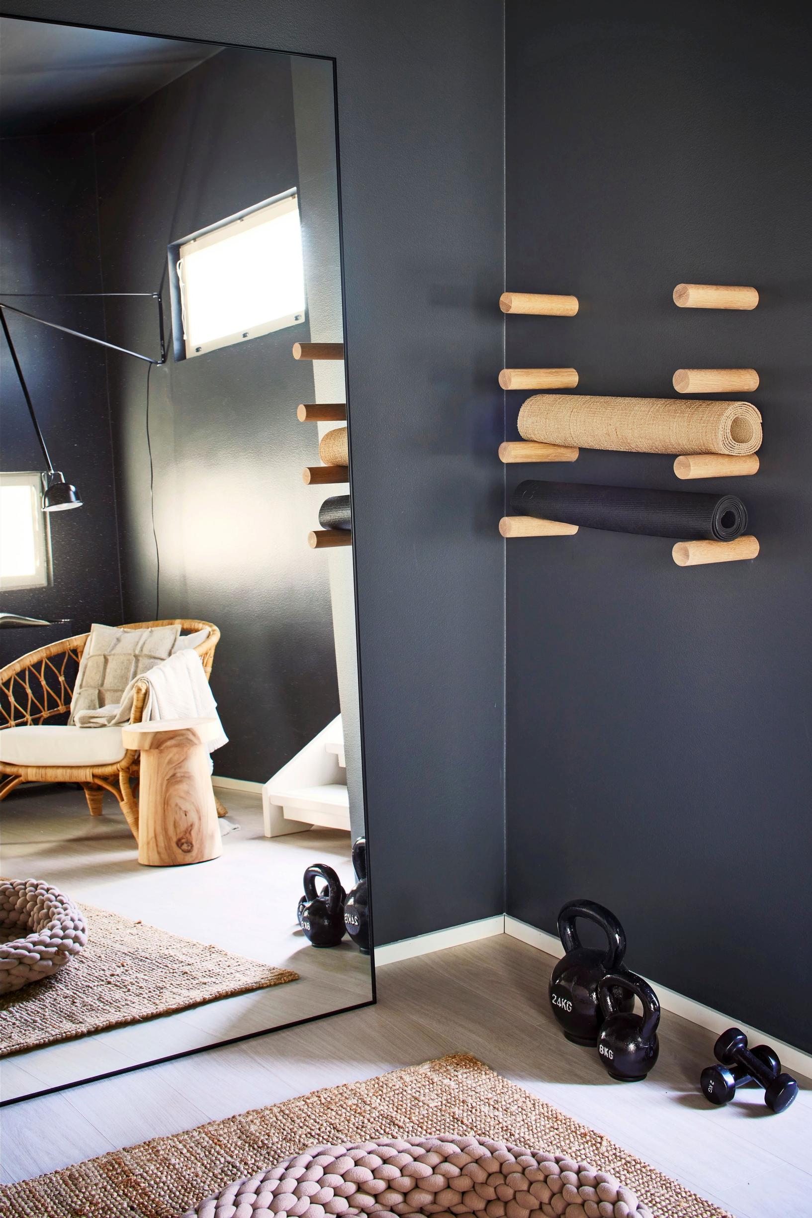 A large mirror and workout equipment in the corner of a dark bedroom.