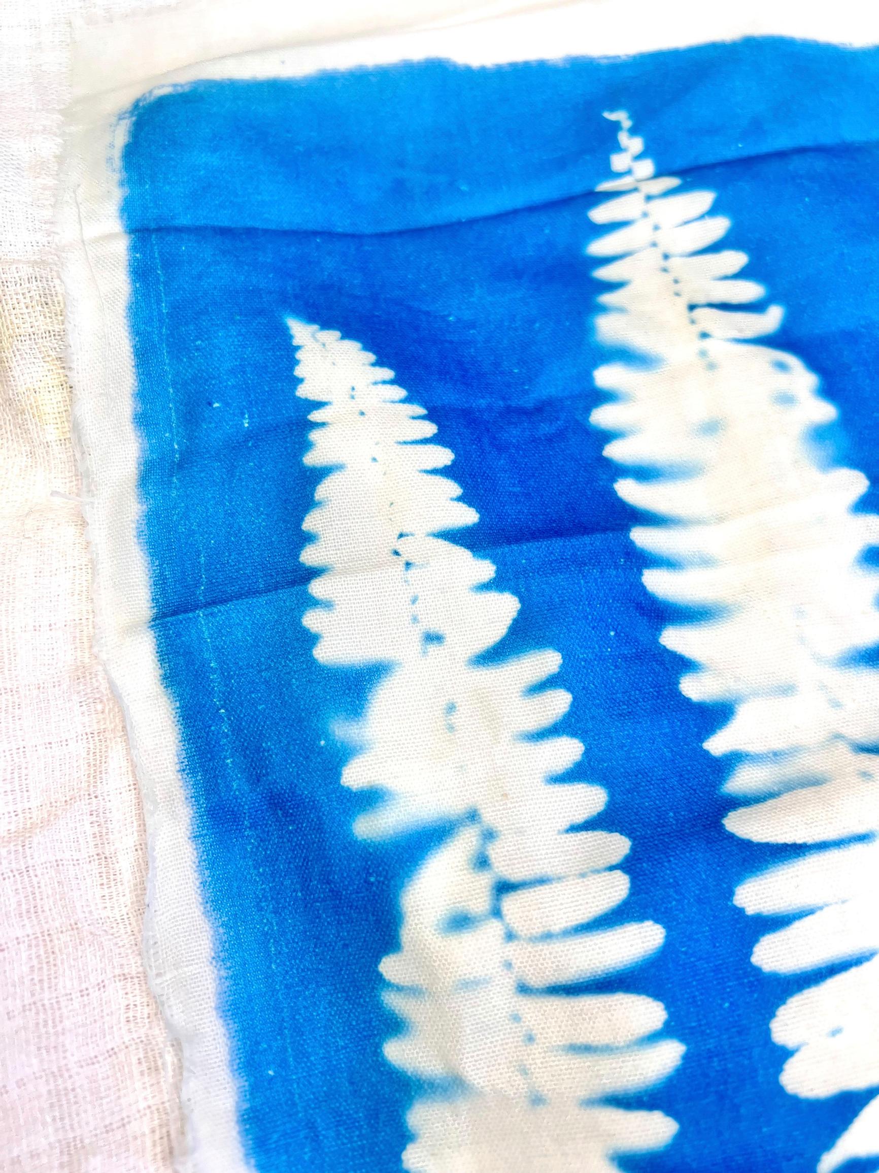 Cyanotype tutorial: When you wash the fabric, a bright blue color remains. The patterned area is white.
