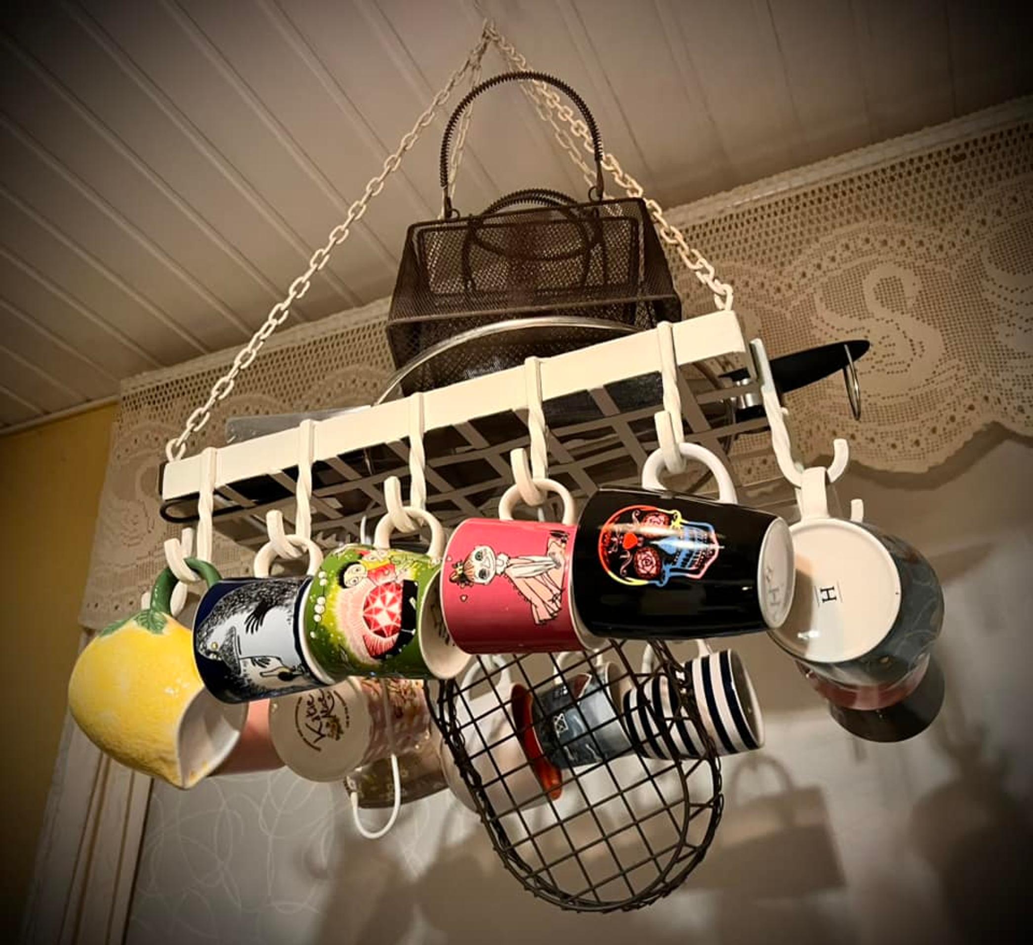 Moomin mugs and other mugs hanging on a ceiling-mounted pot rack
