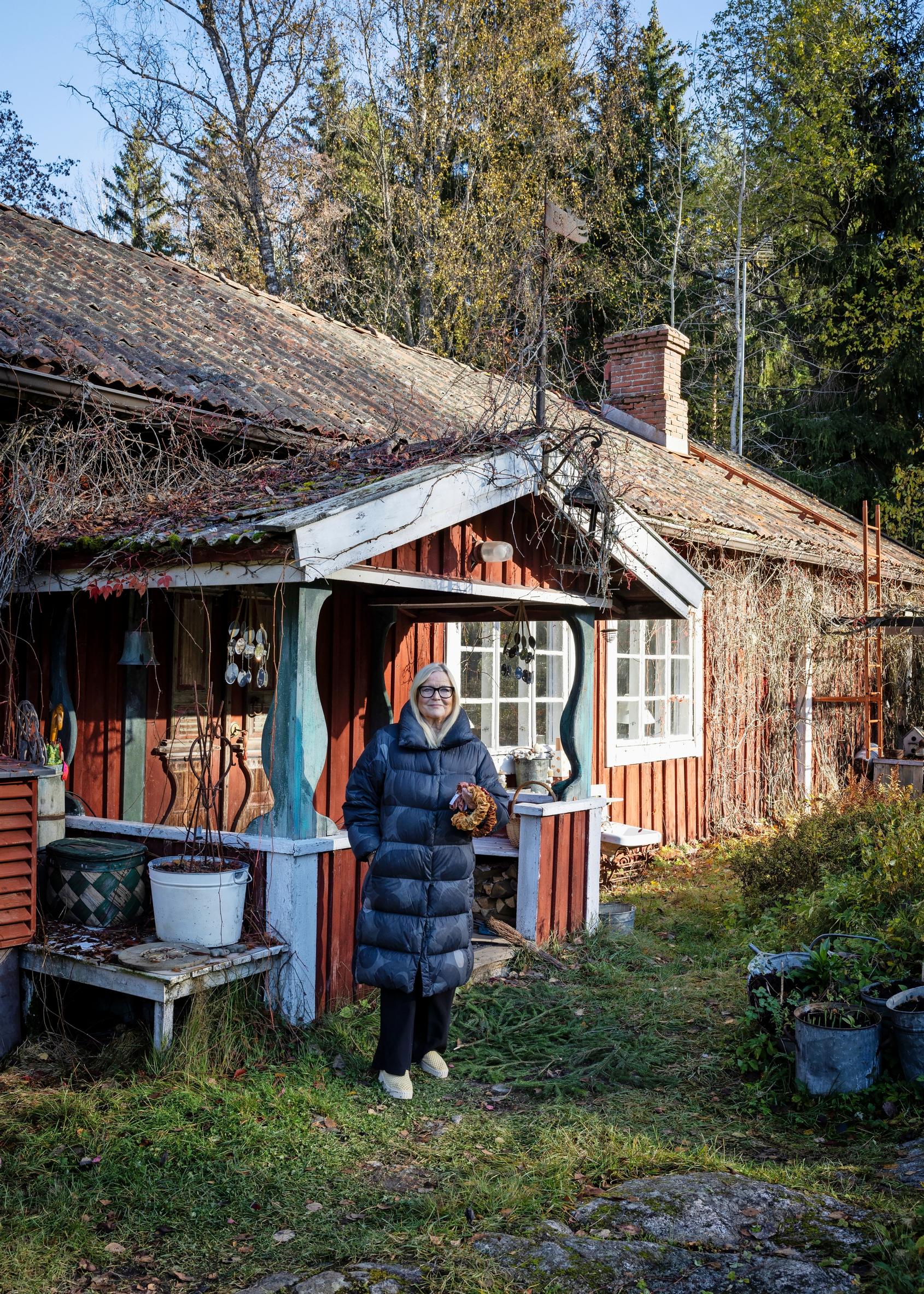 Kerstin Enbom in front of her red cottage.