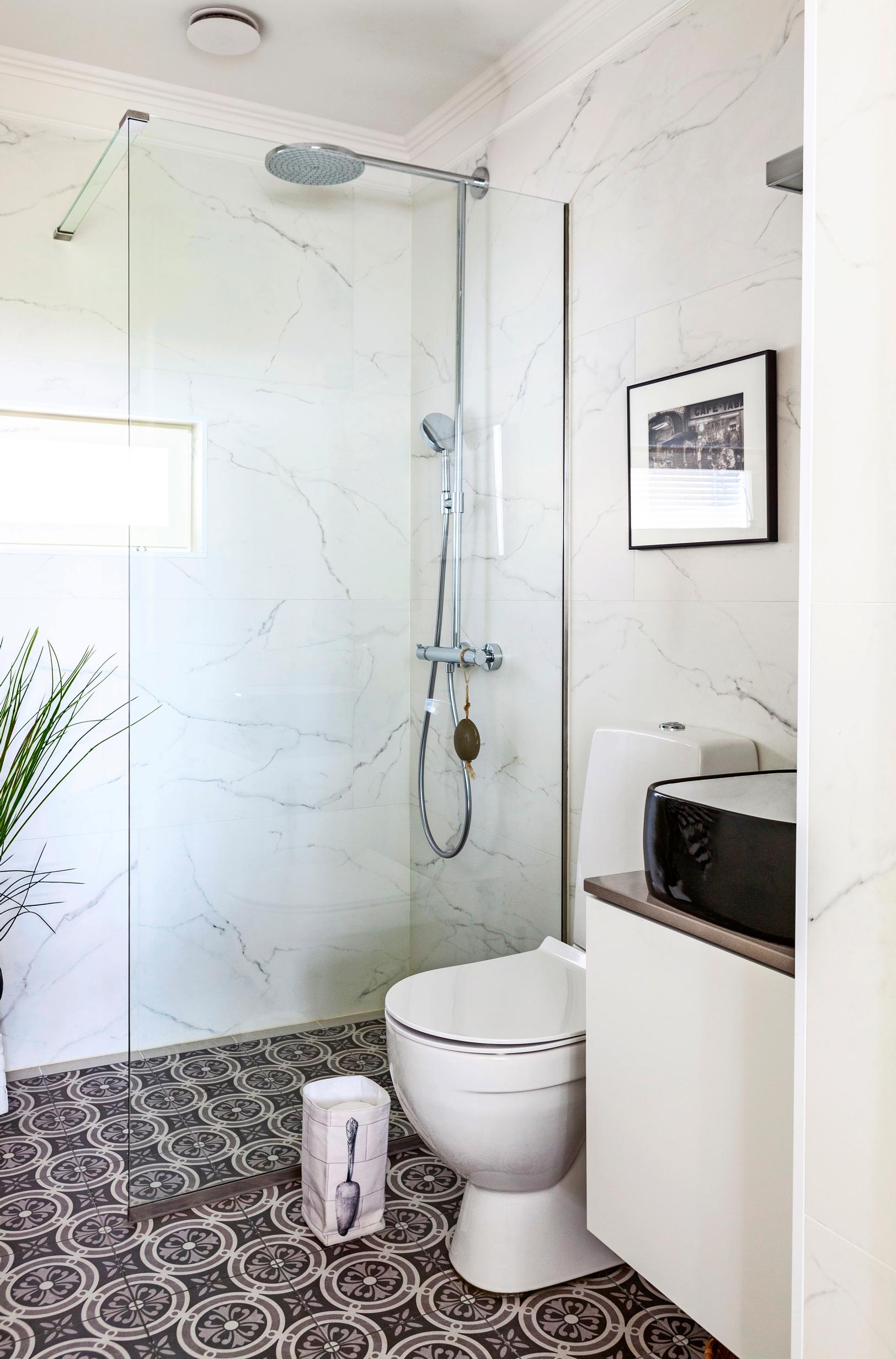 Bathroom with decorative black-and-white floor tiles and marble-effect walls
