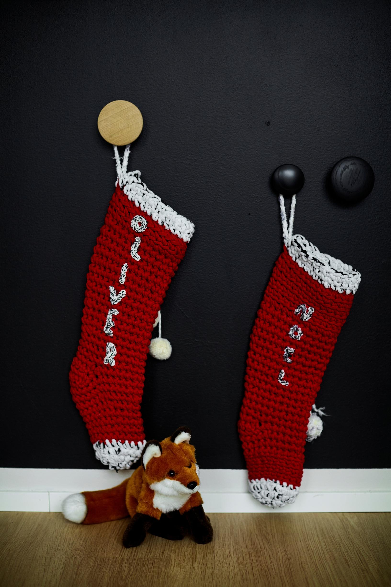 two red Christmas stockings hanging and a plush fox