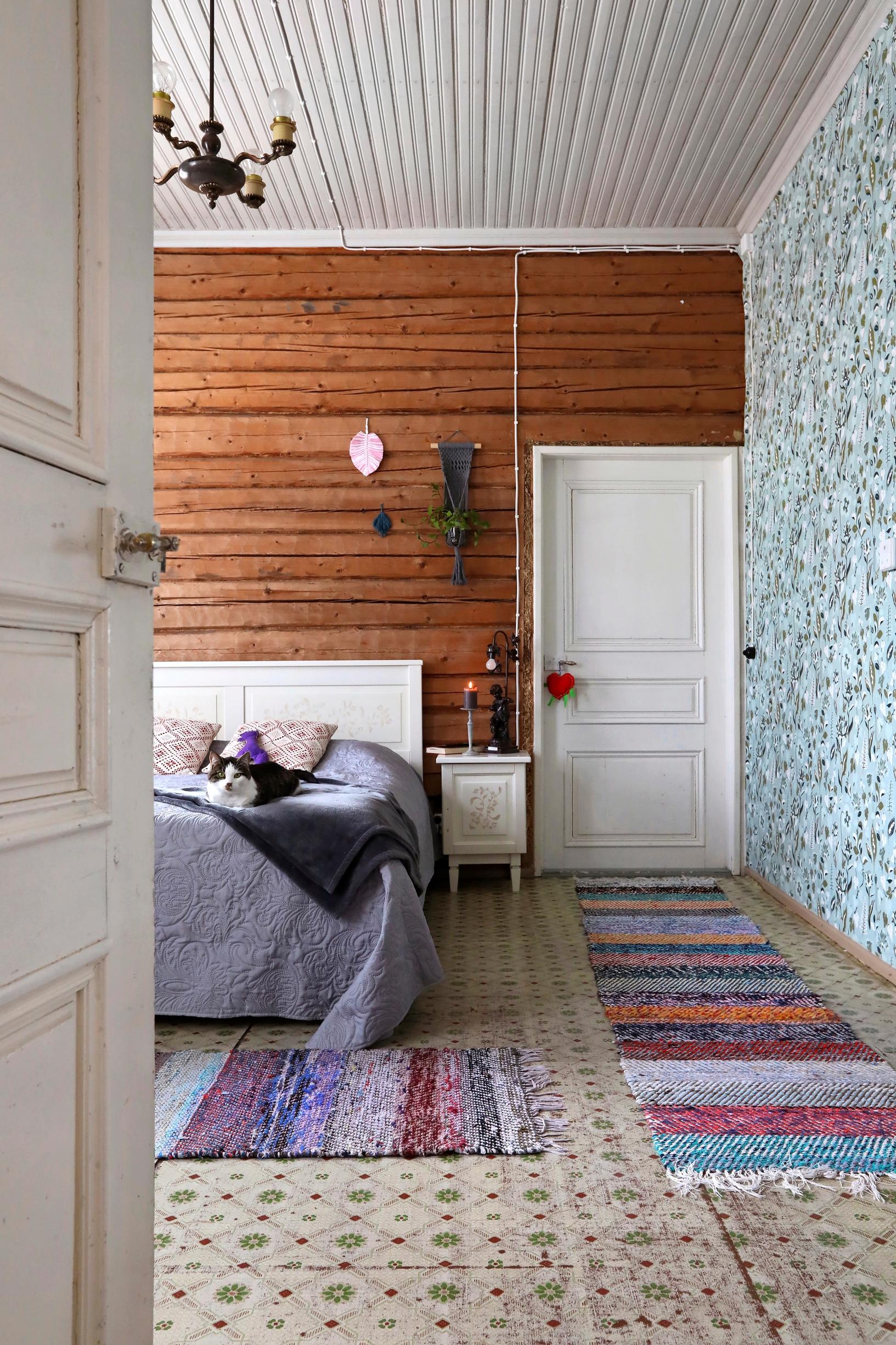 The bedroom has a linoleum floor and wallpaper on the side wall