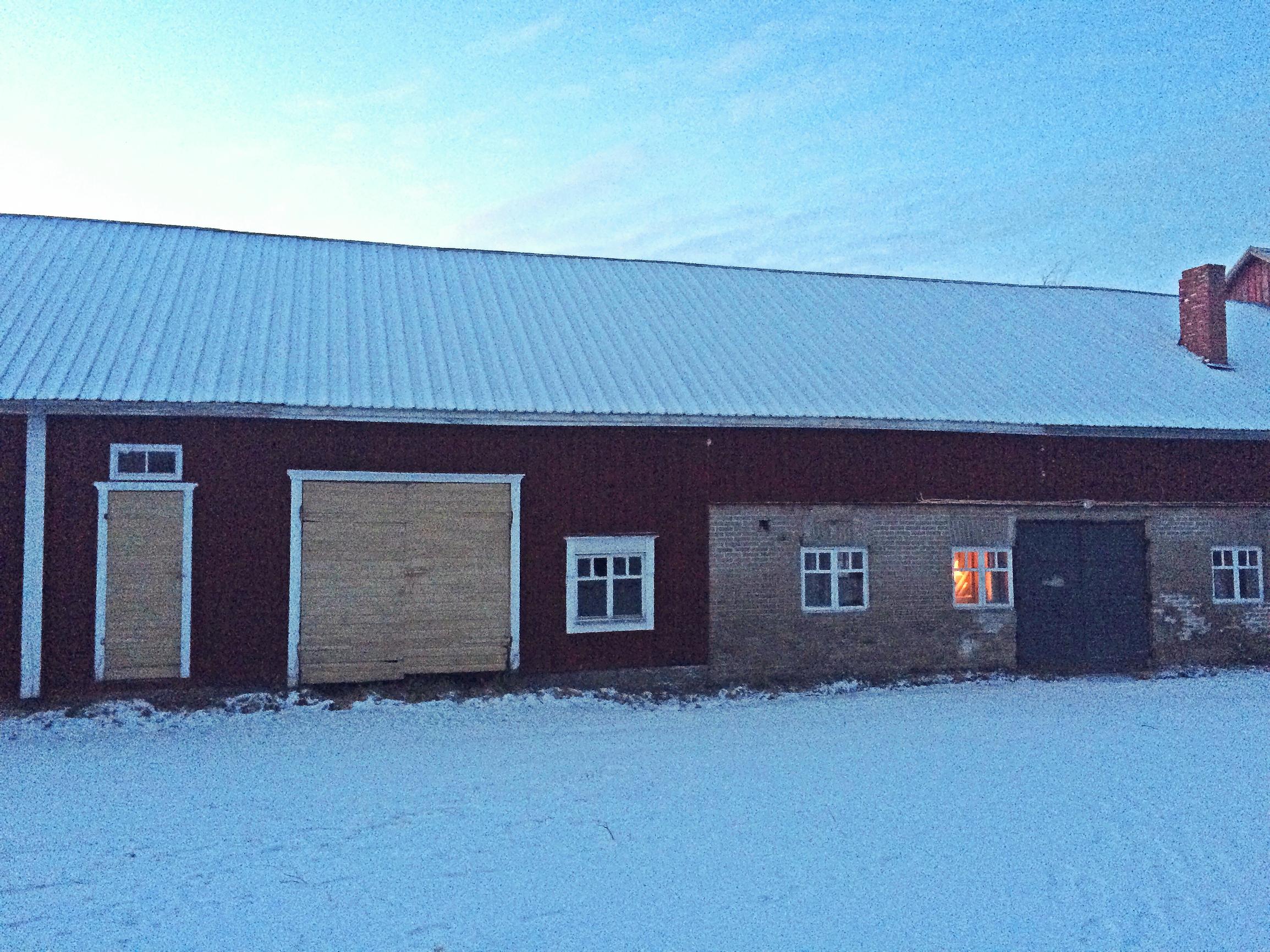 An old barn with a red wooden extension attached to it.