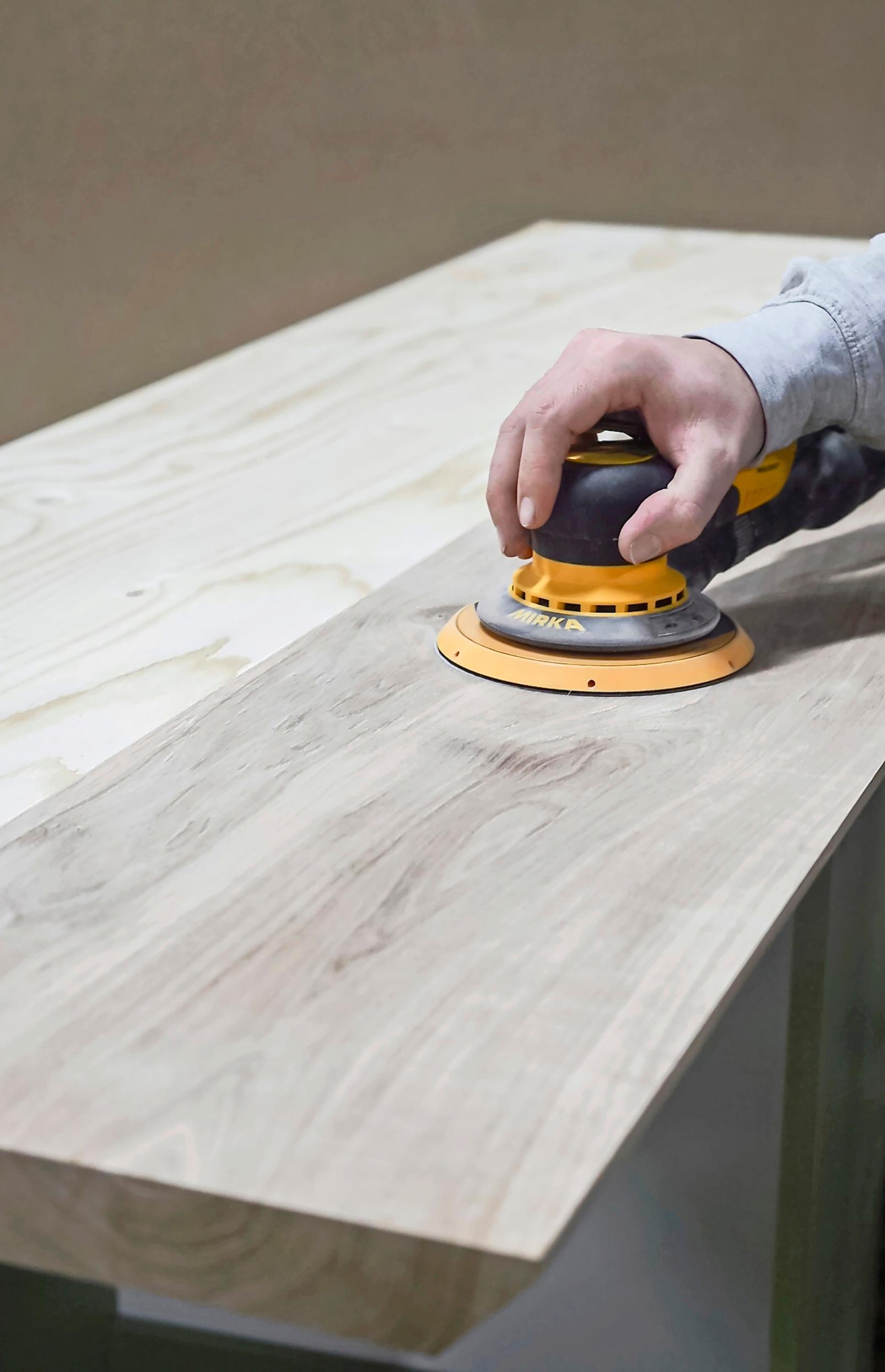 Sanding the board with a sander