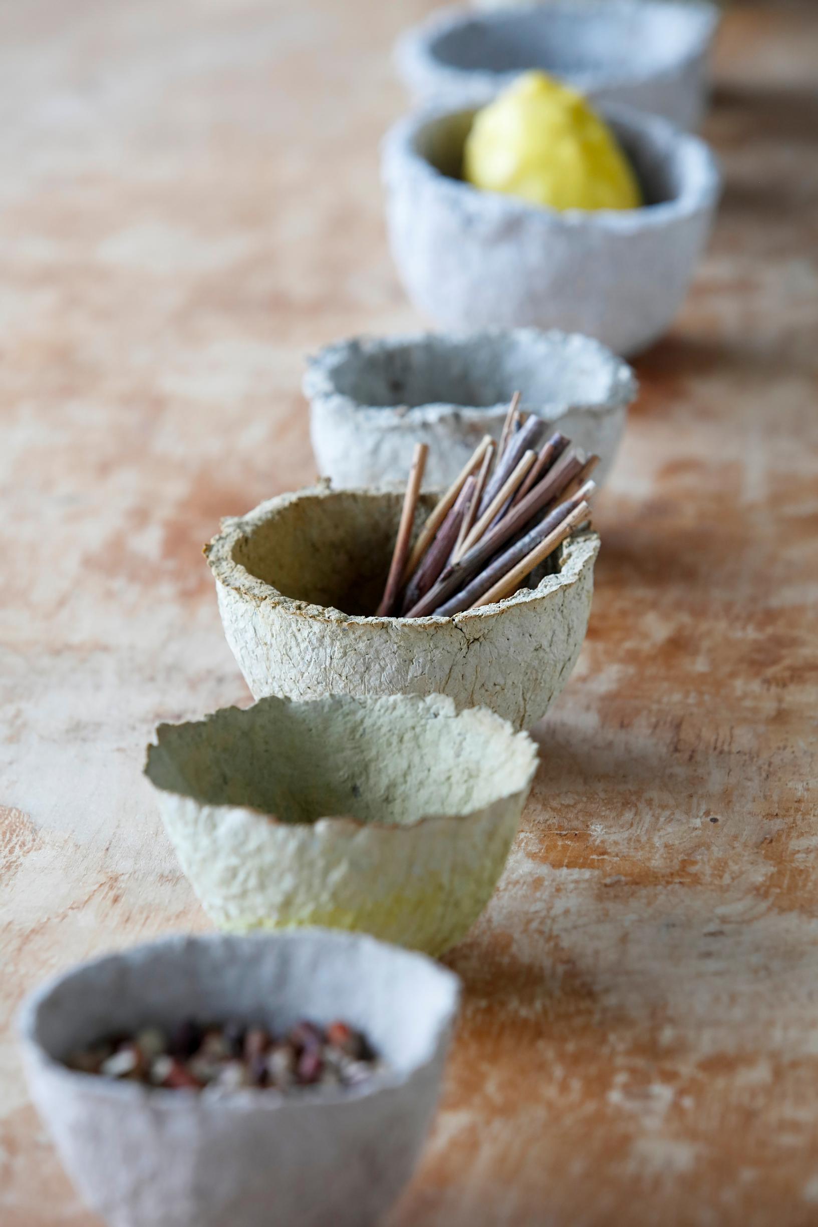 Papier-mâché bowls lined up on a table.
