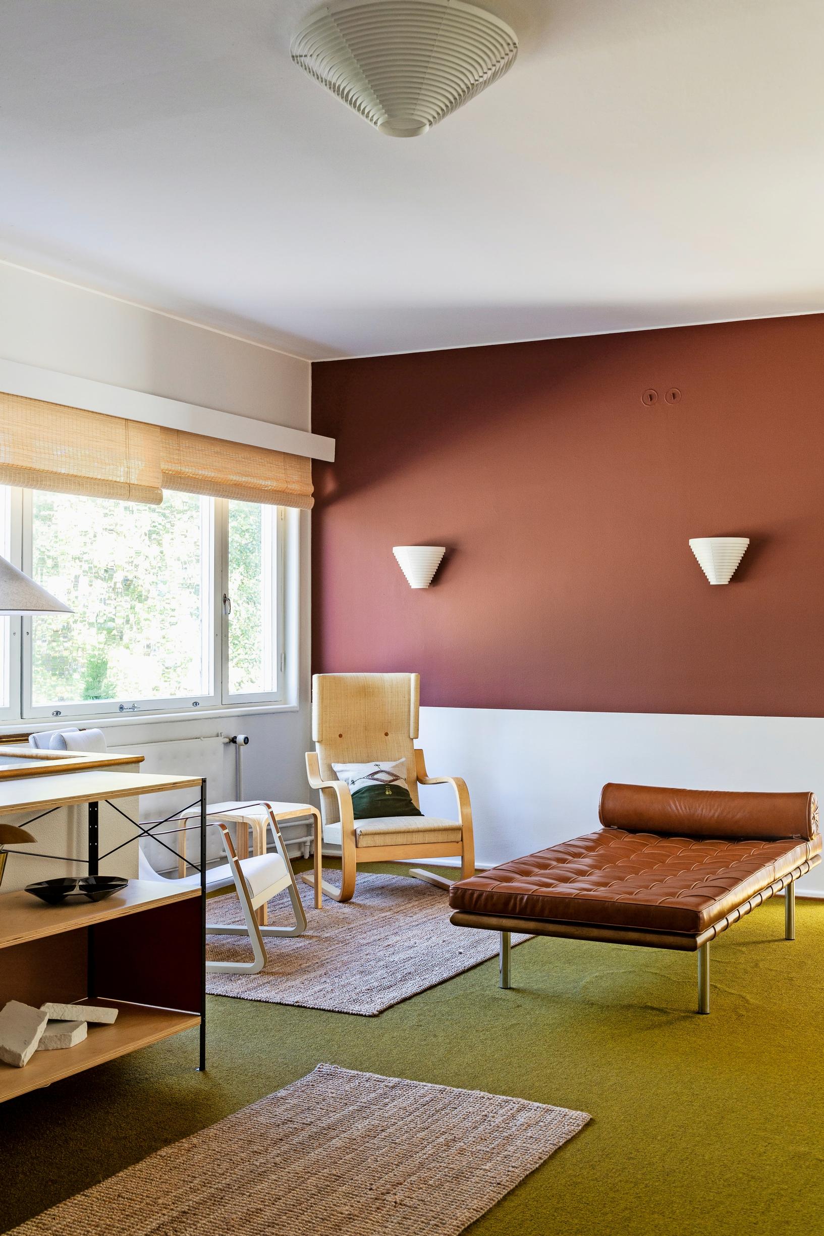 In the upstairs landing with reddish-brown walls and a Barcelona daybed