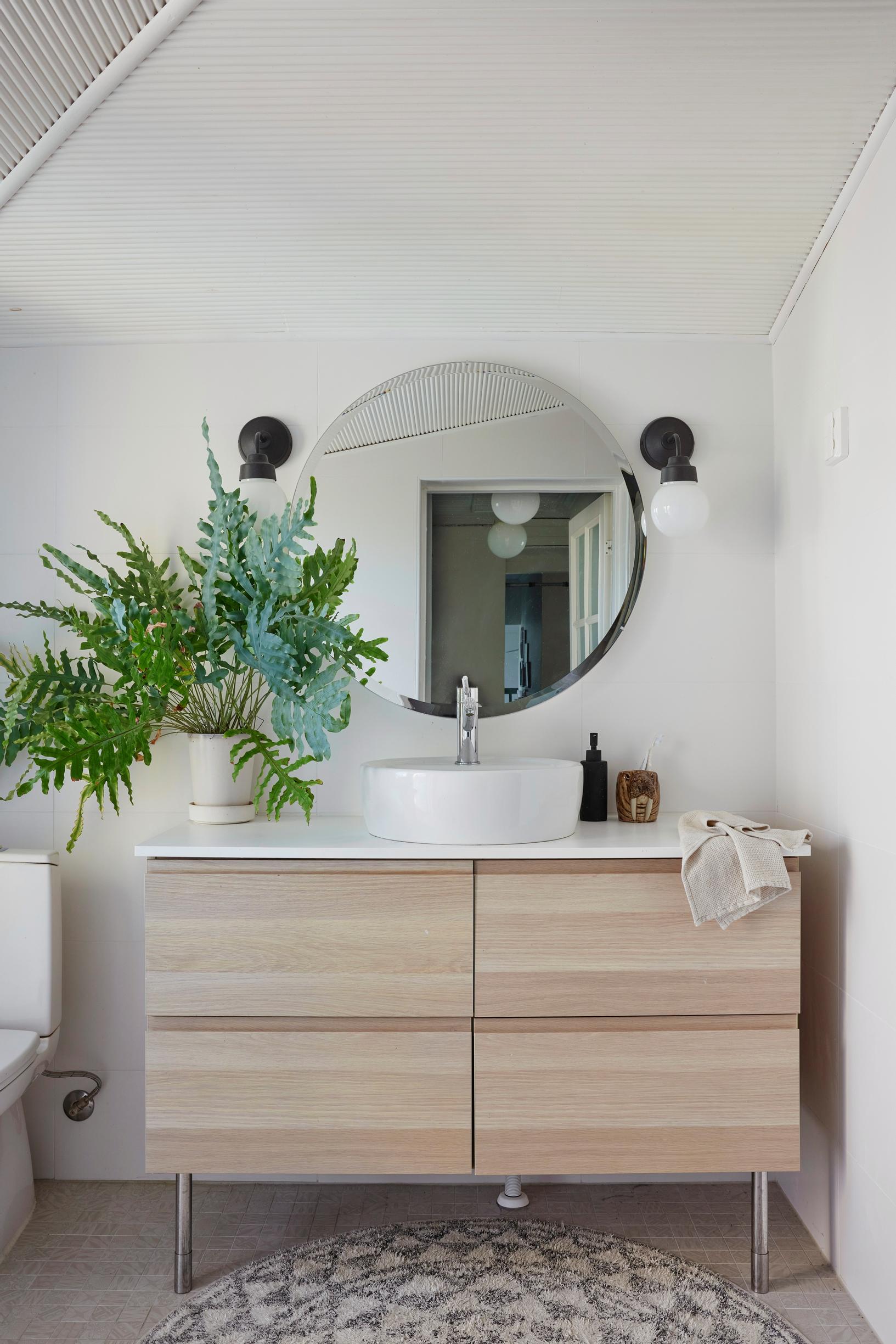 A vanity and round mirror in the bathroom