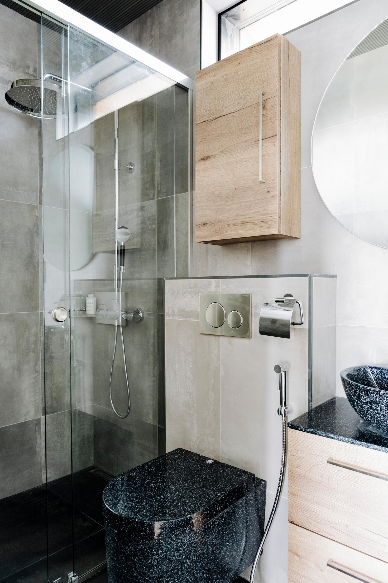A large mirror gives a spacious feel to the bathroom with a wood composite toilet and sink.