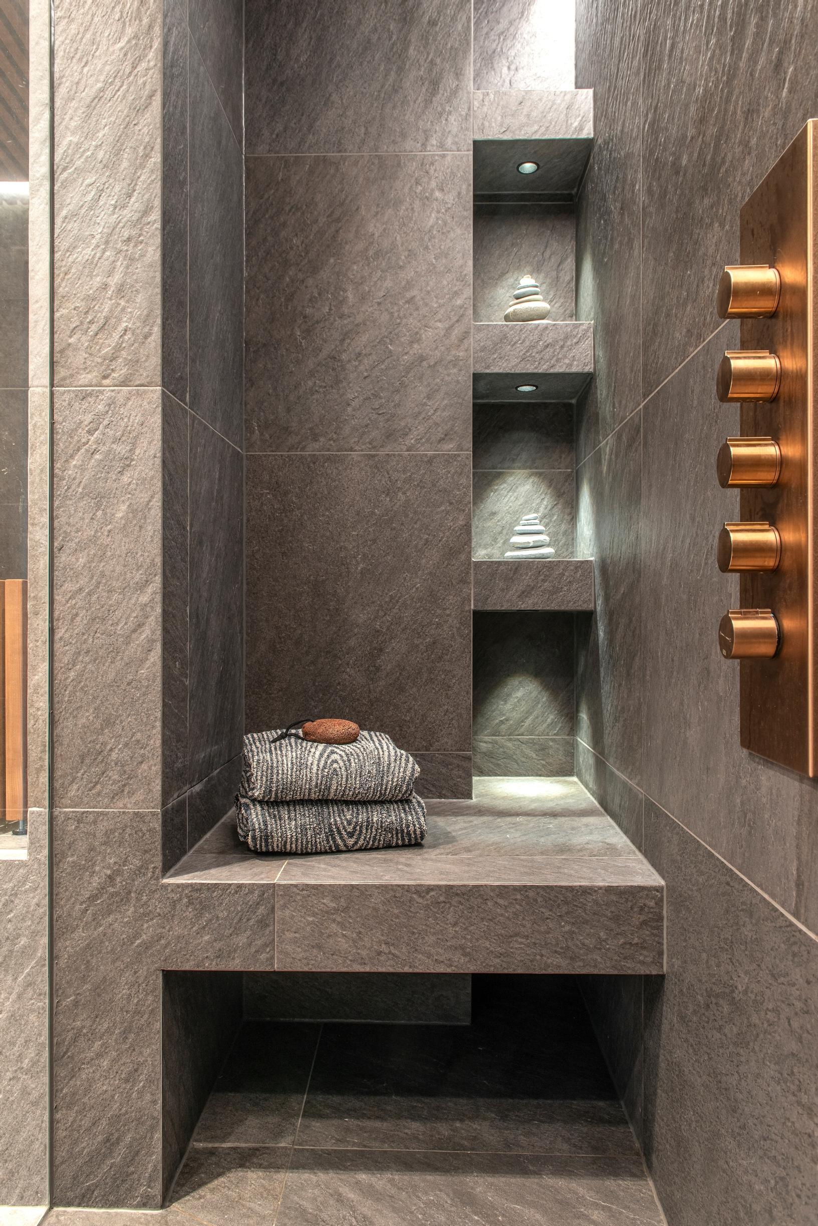 A recessed shelf in the bathroom wall for towels