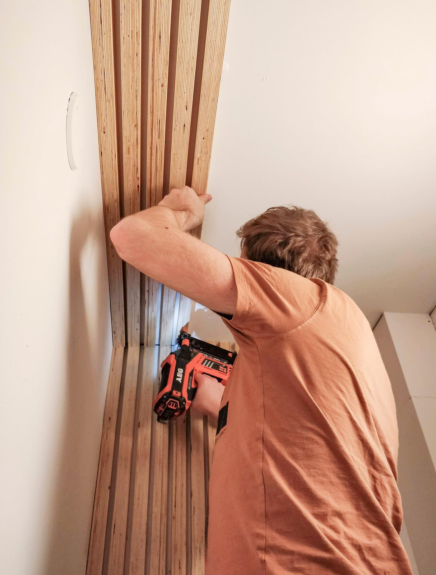 Attaching the slats to the wall with a nail gun