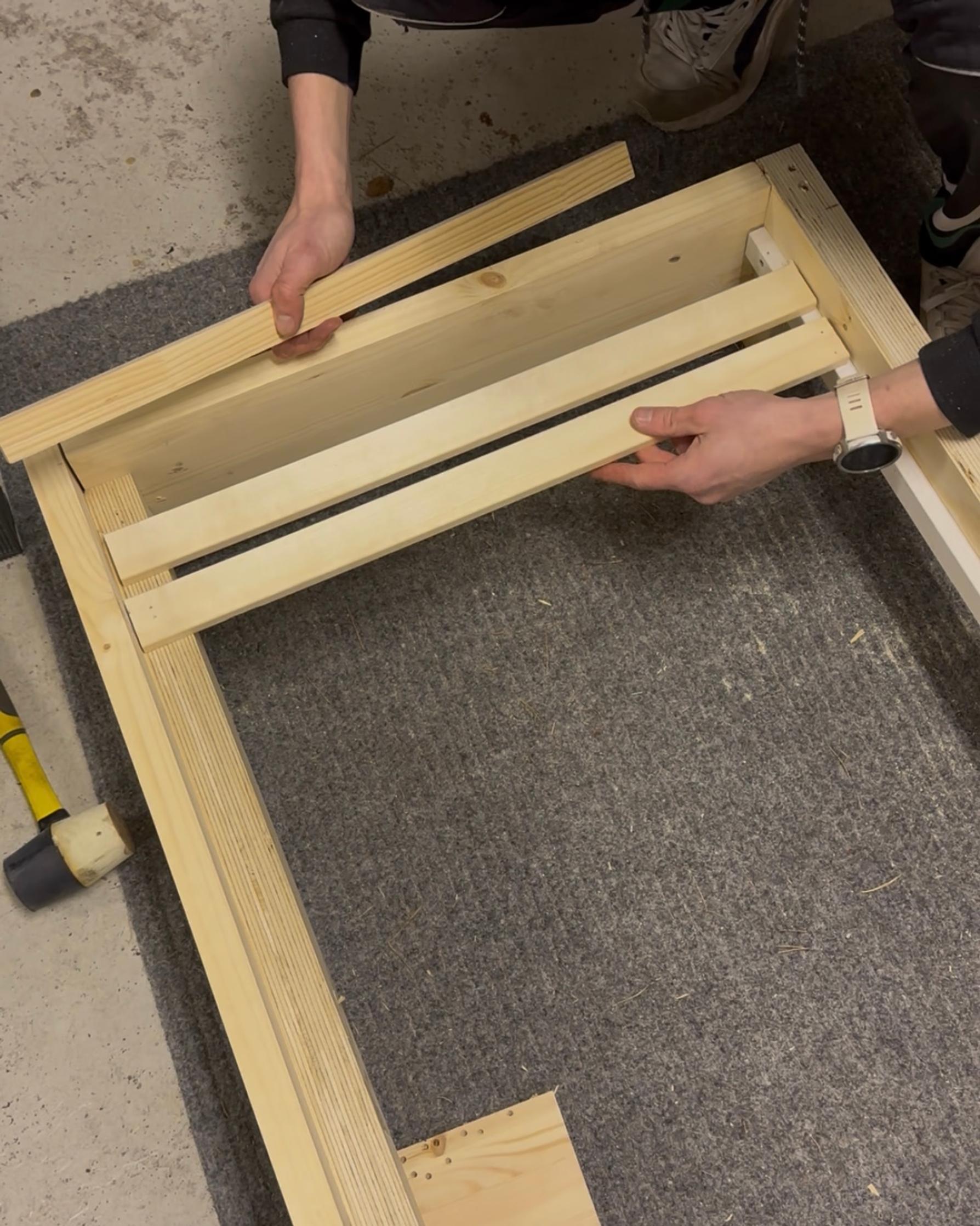 Attaching wooden slats to the front of the wooden frame.