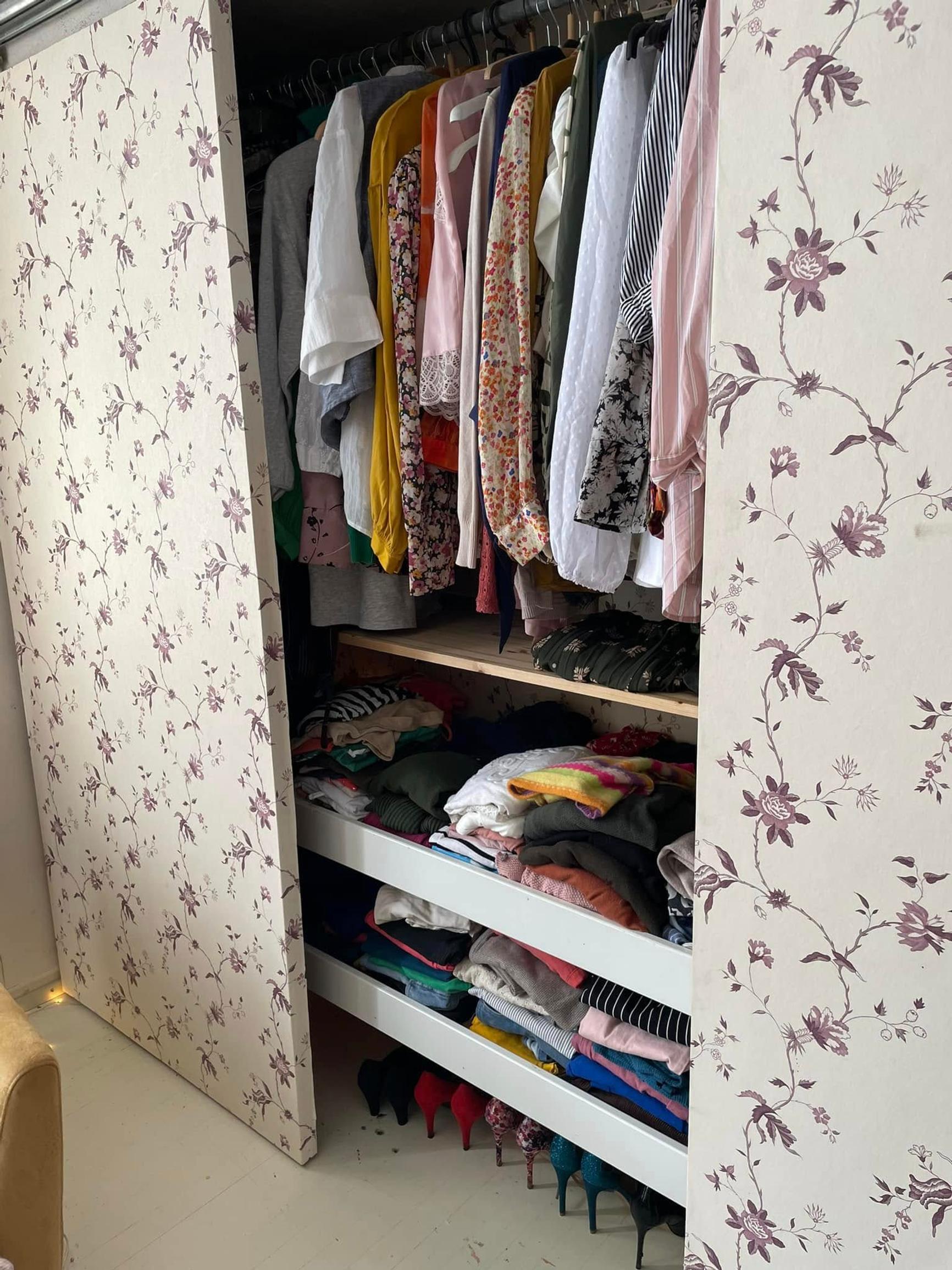 The closet has three open shelves for clothes, with space for hanging garments above them.