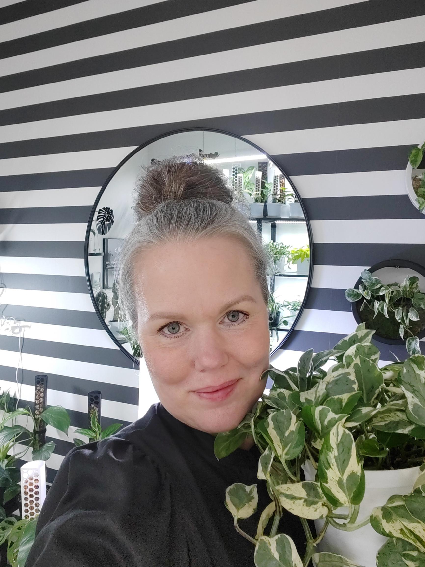 Nina is holding a golden pothos, Epipremnum aureum ‘Pearls & Jade’.