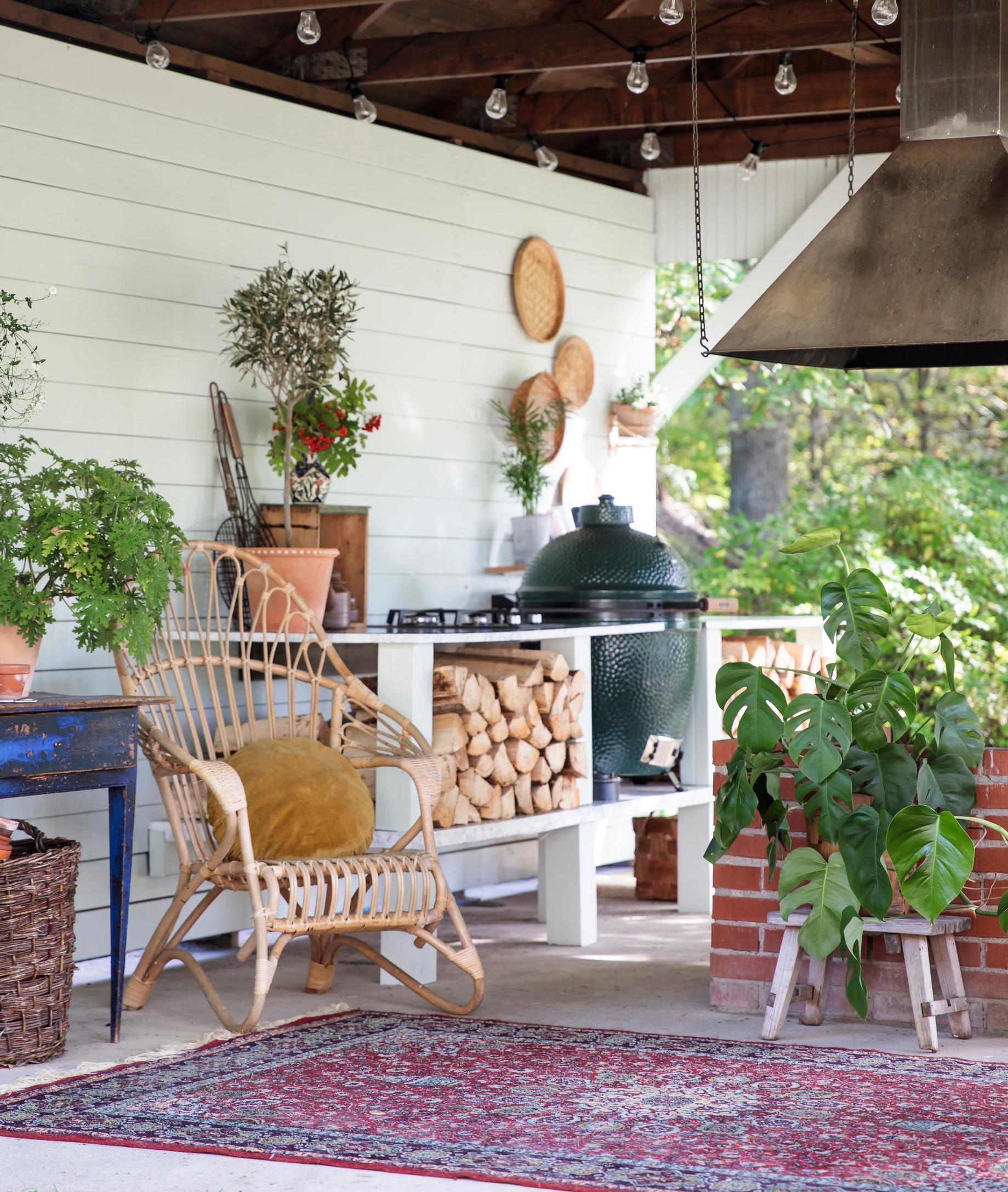 Rattan, clay dishes, and houseplants—an old camp school’s barbecue shelter was transformed into a cozy summer oasis