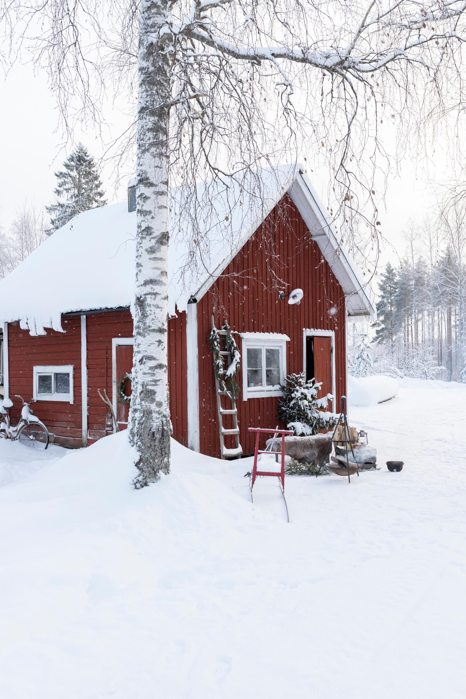 A red sauna building in the snowy landscape