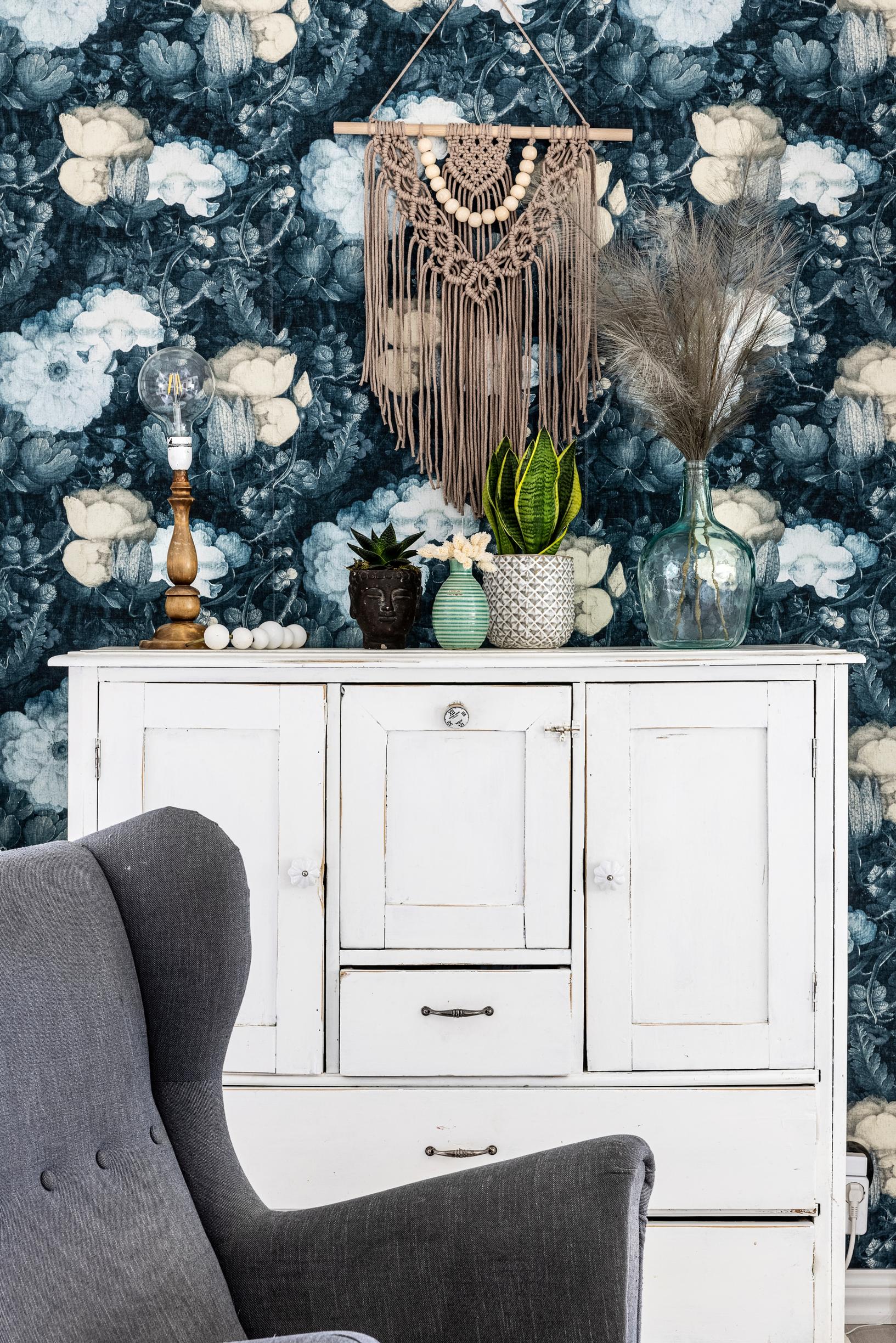 A dresser painted with chalk paint in front of floral wallpaper