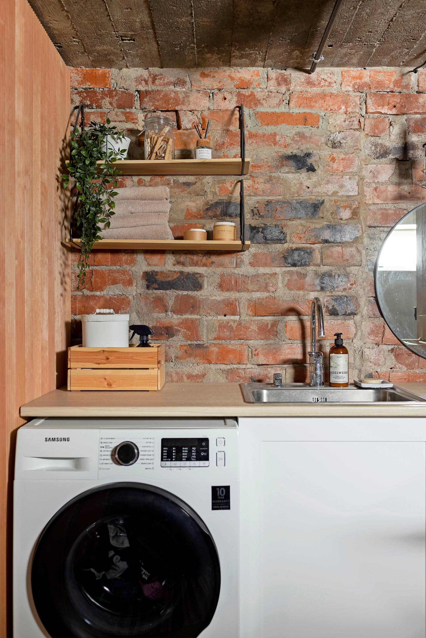 Laundry room with brick walls