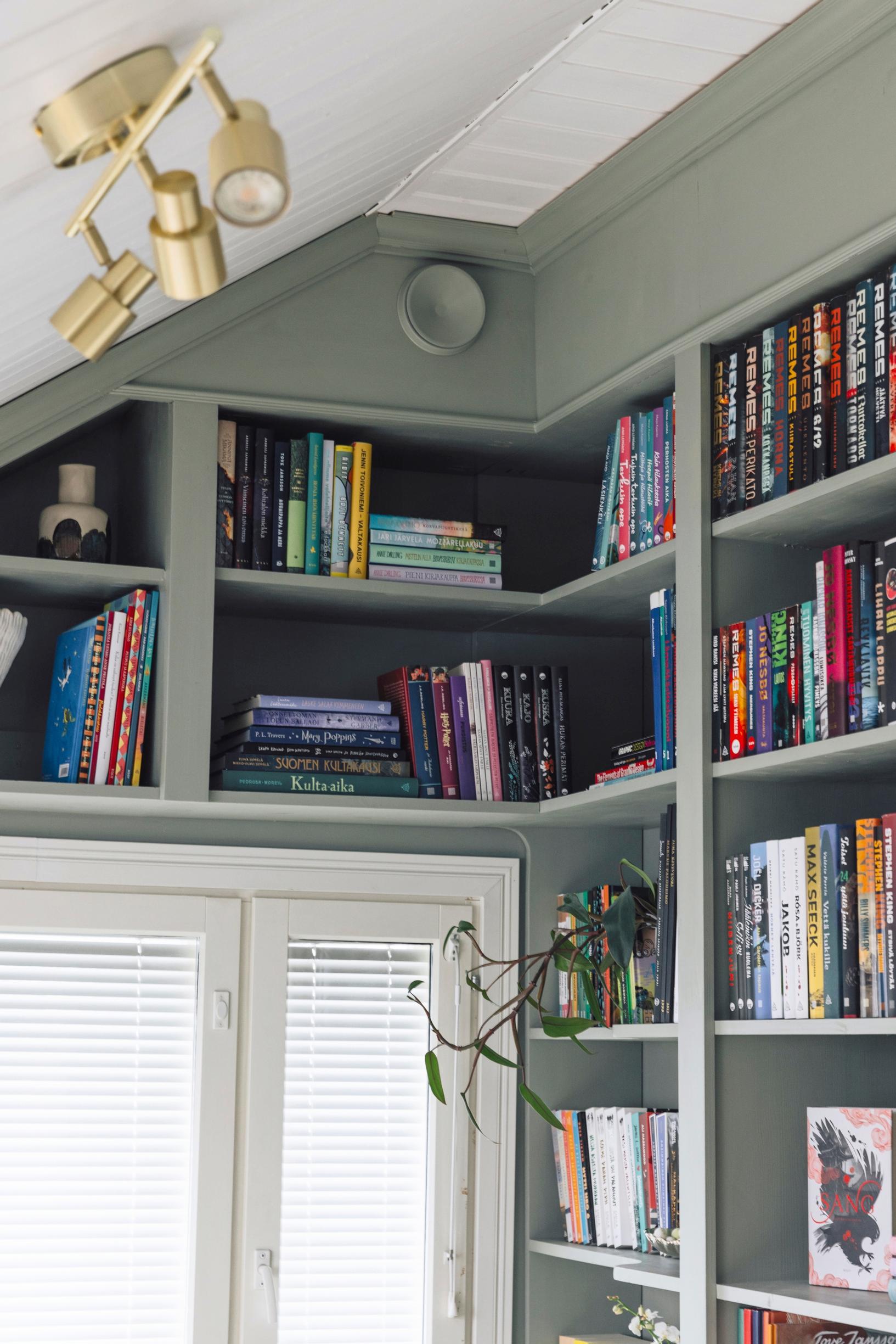 Above and next to the window in the corner of the room, there are open shelves.