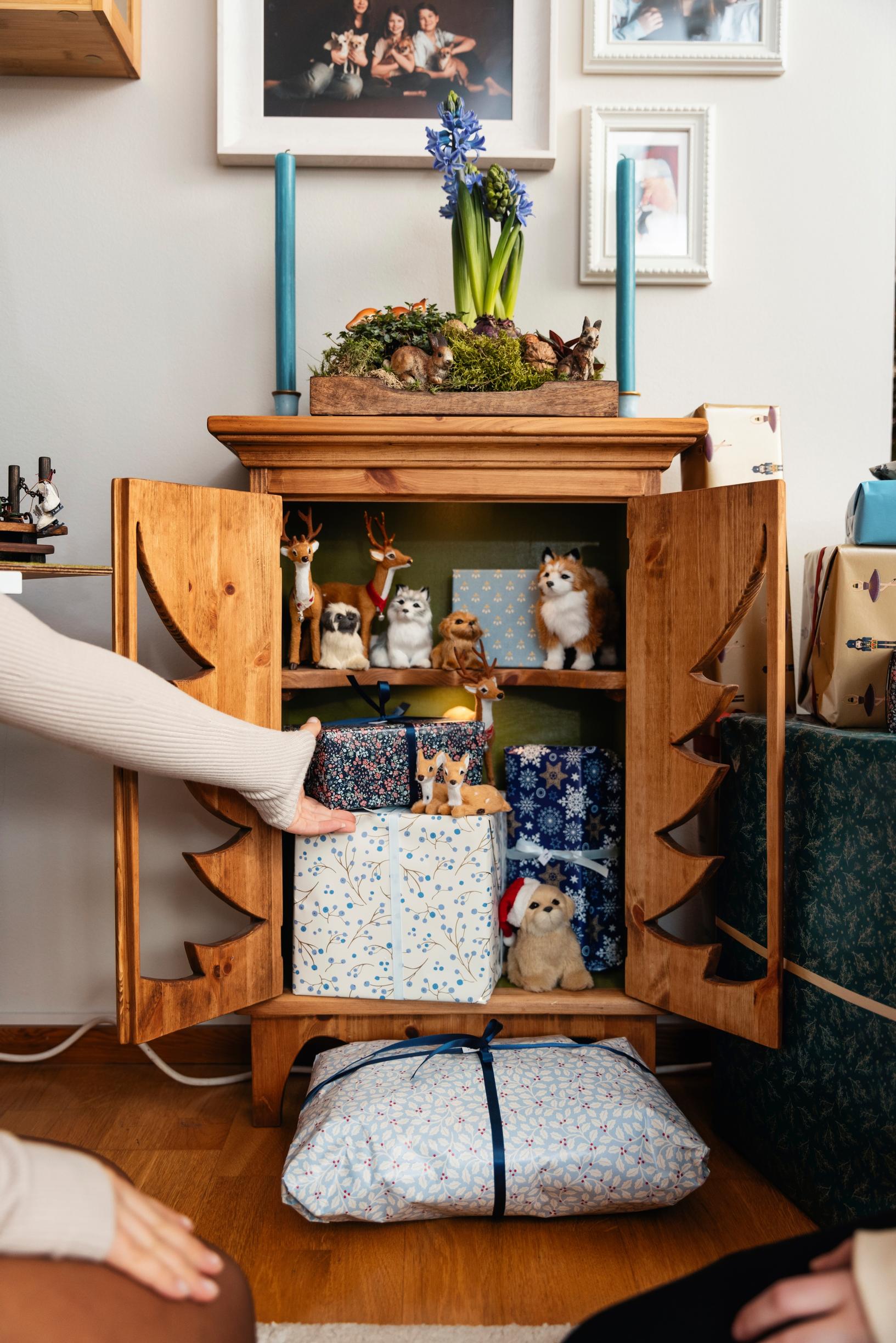 Riikka’s Christmas cabinet with a cutout shaped like a Christmas tree. It doubles as an Advent calendar, with packages inside.
