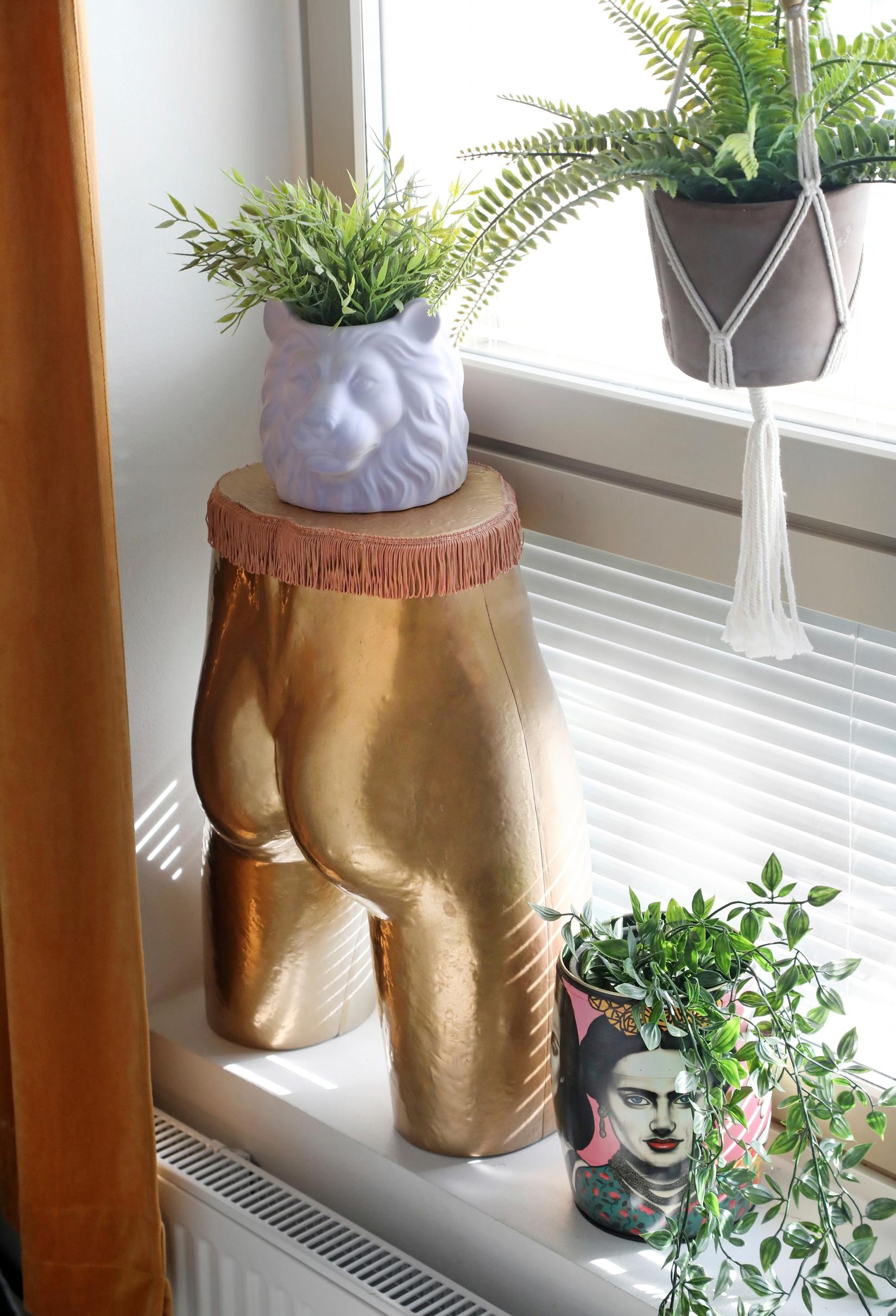 Golden butt torso on the windowsill