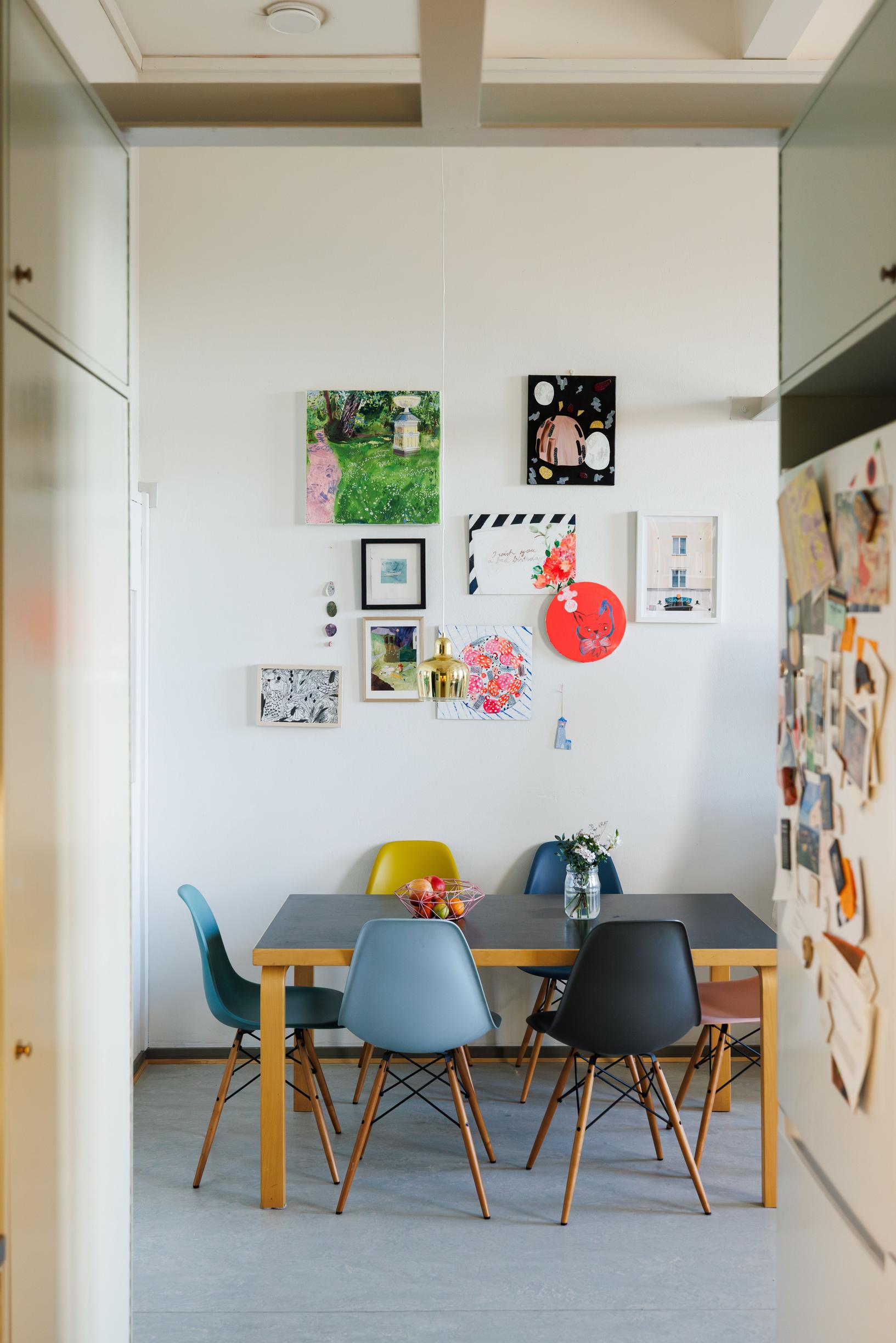 a dining area with mismatched Eames chairs