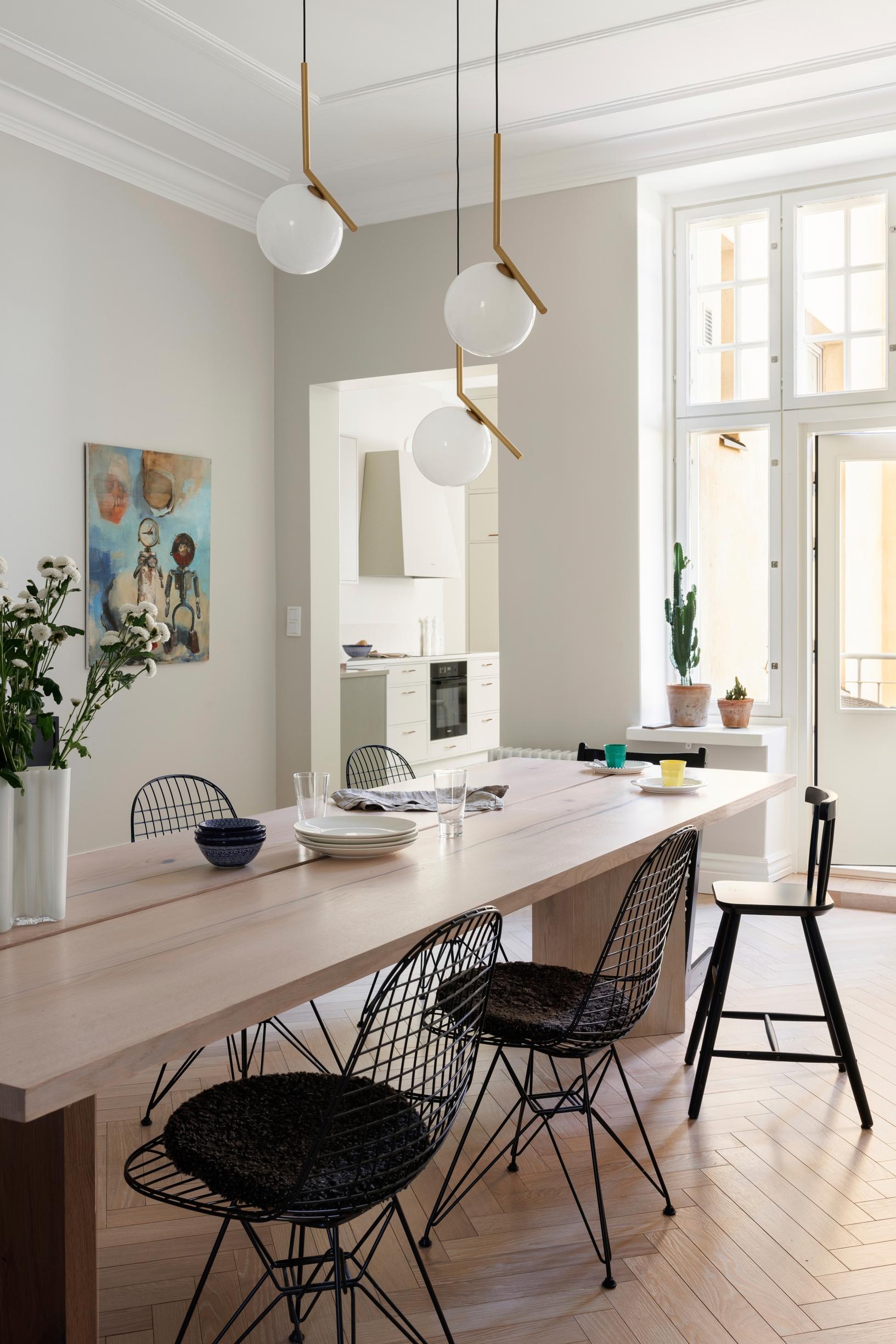 The dining area’s long table with slender black chairs around it.