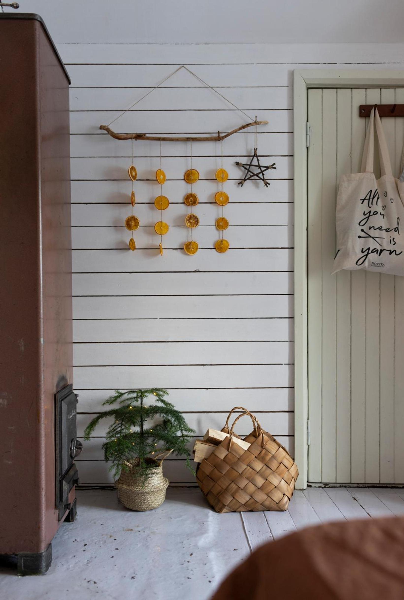 Dried orange slices attached to a branch, hung on the wall.