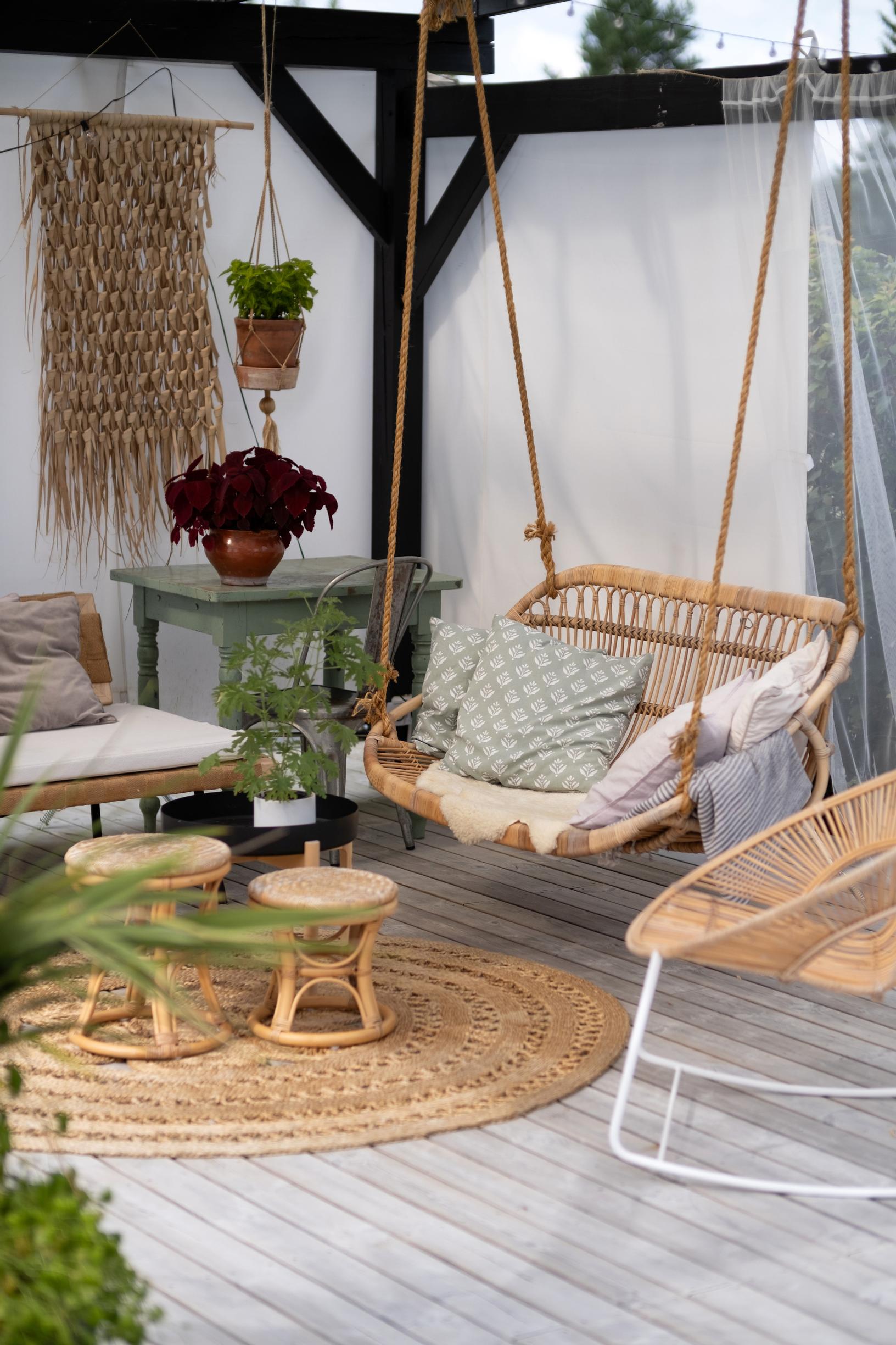 A hanging rattan swing dangles from the pergola’s ceiling.