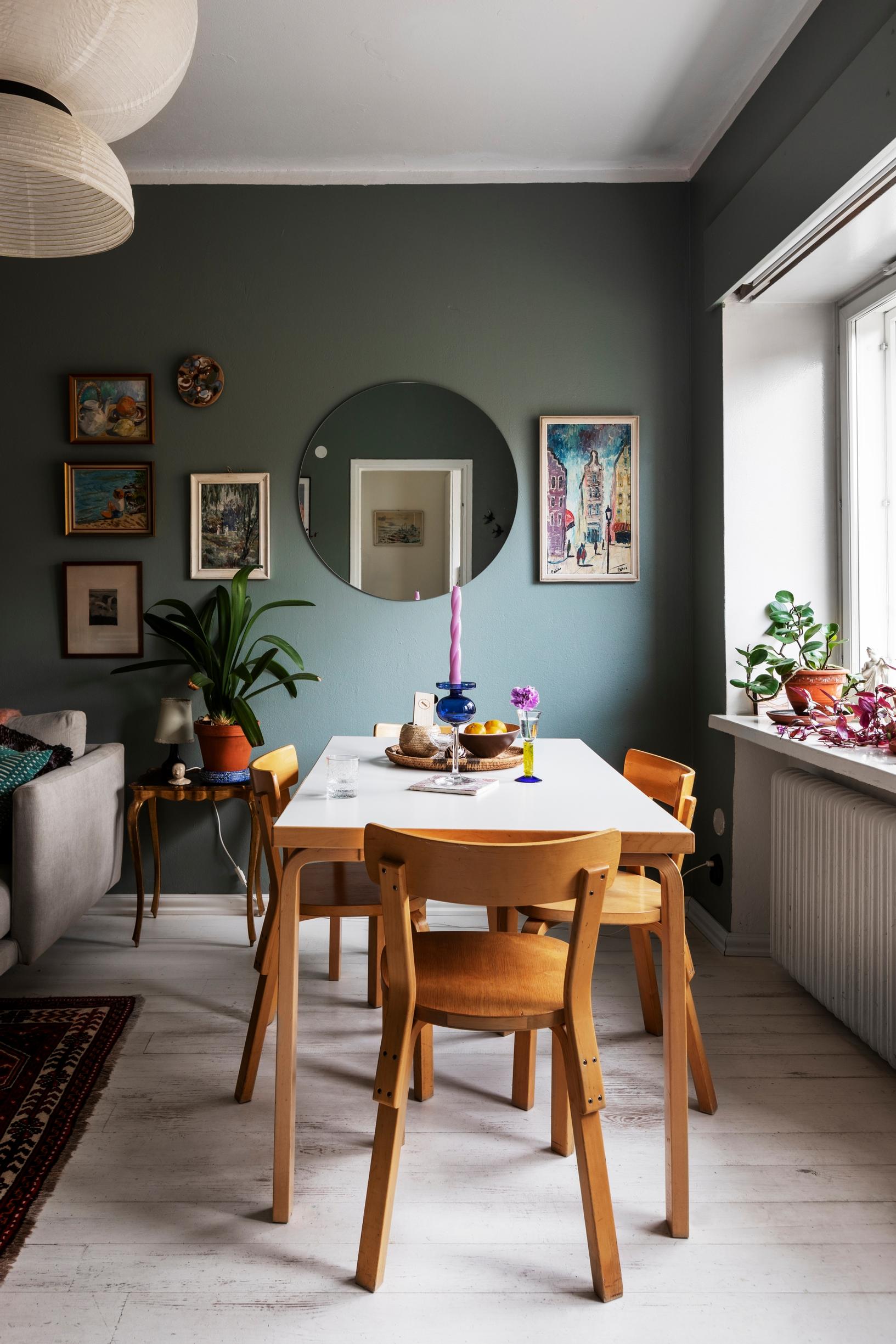 An old linoleum-topped Artek dining table in a green-walled dining area