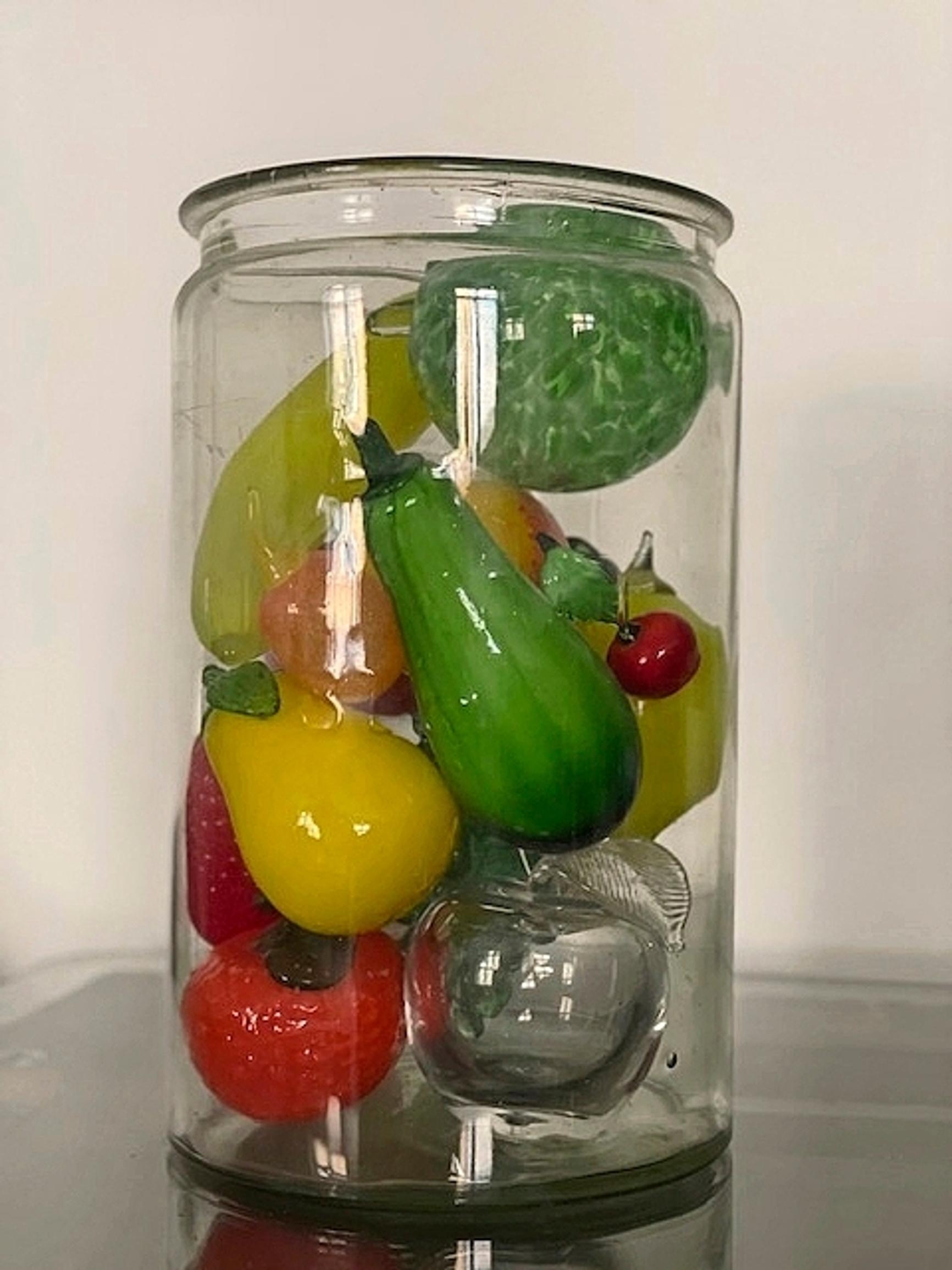 A glass jar full of glass fruit