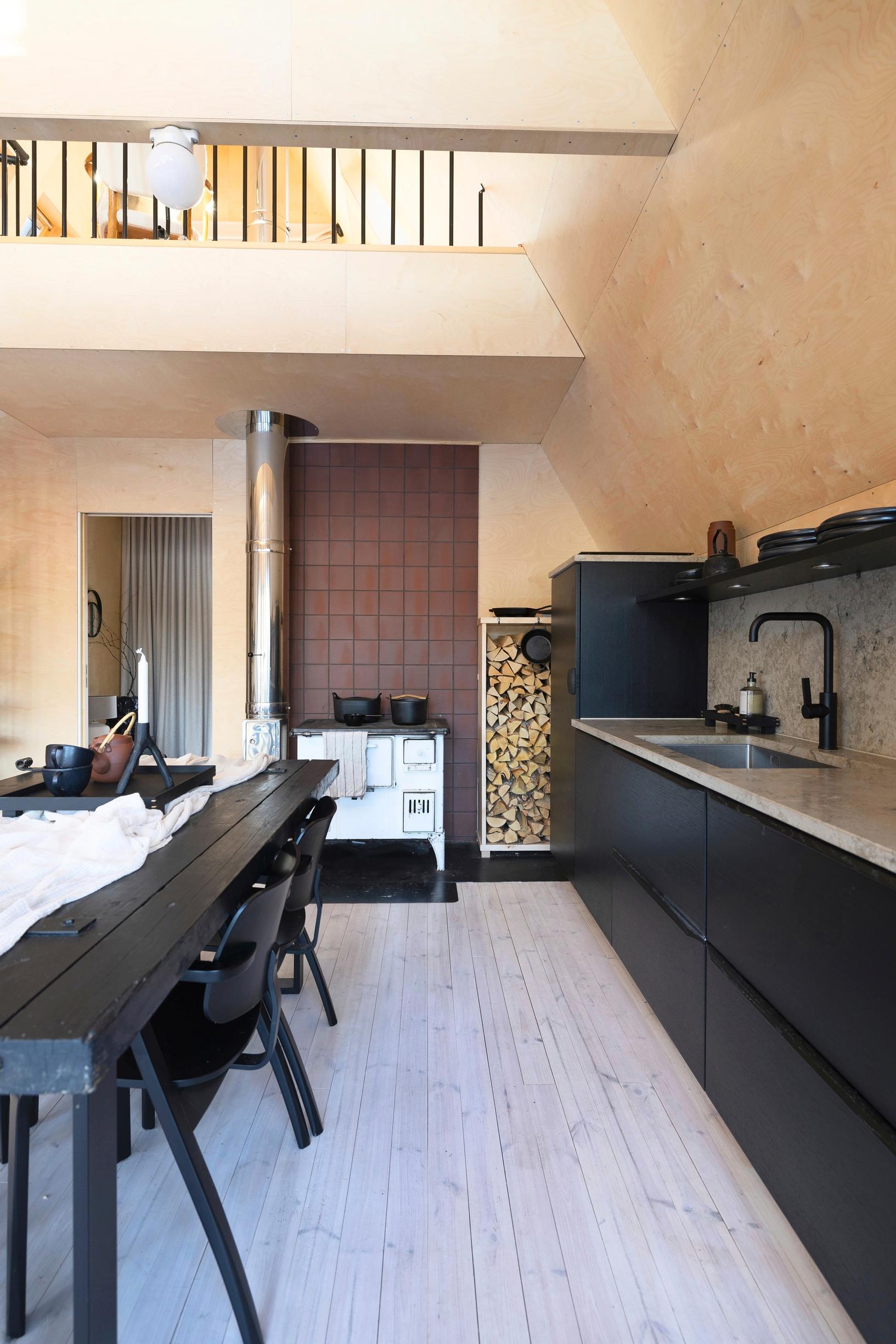 Limestone countertops and dark red tiling in the black kitchen